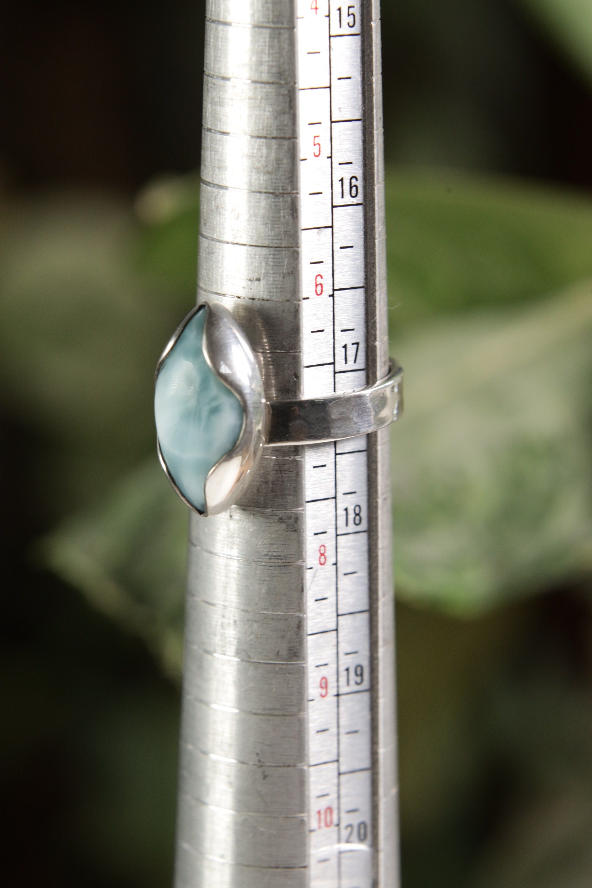 Larimar adjustable ring shown beside a ruler for scale, with eye-shaped blue stone and sterling silver band.