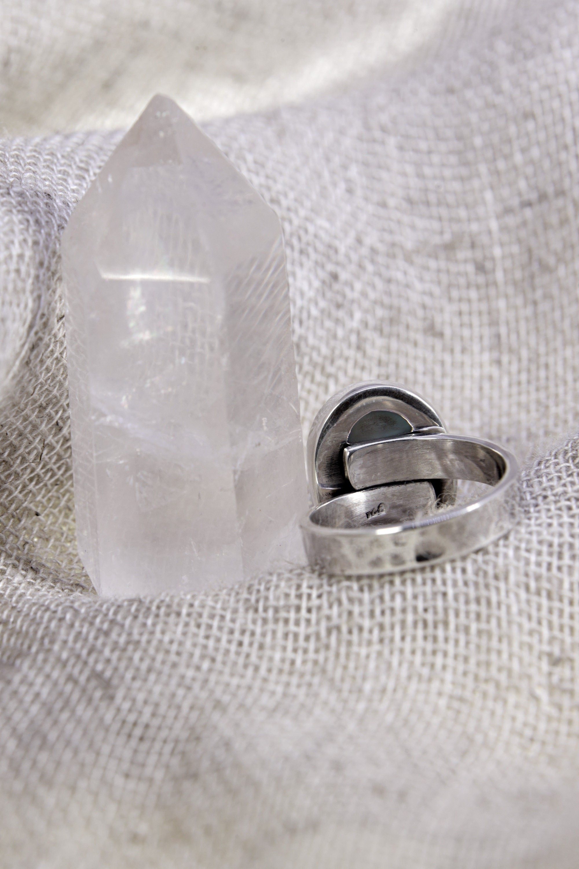 Back view of oval Larimar adjustable ring showing open sterling silver band and handmade silver construction.