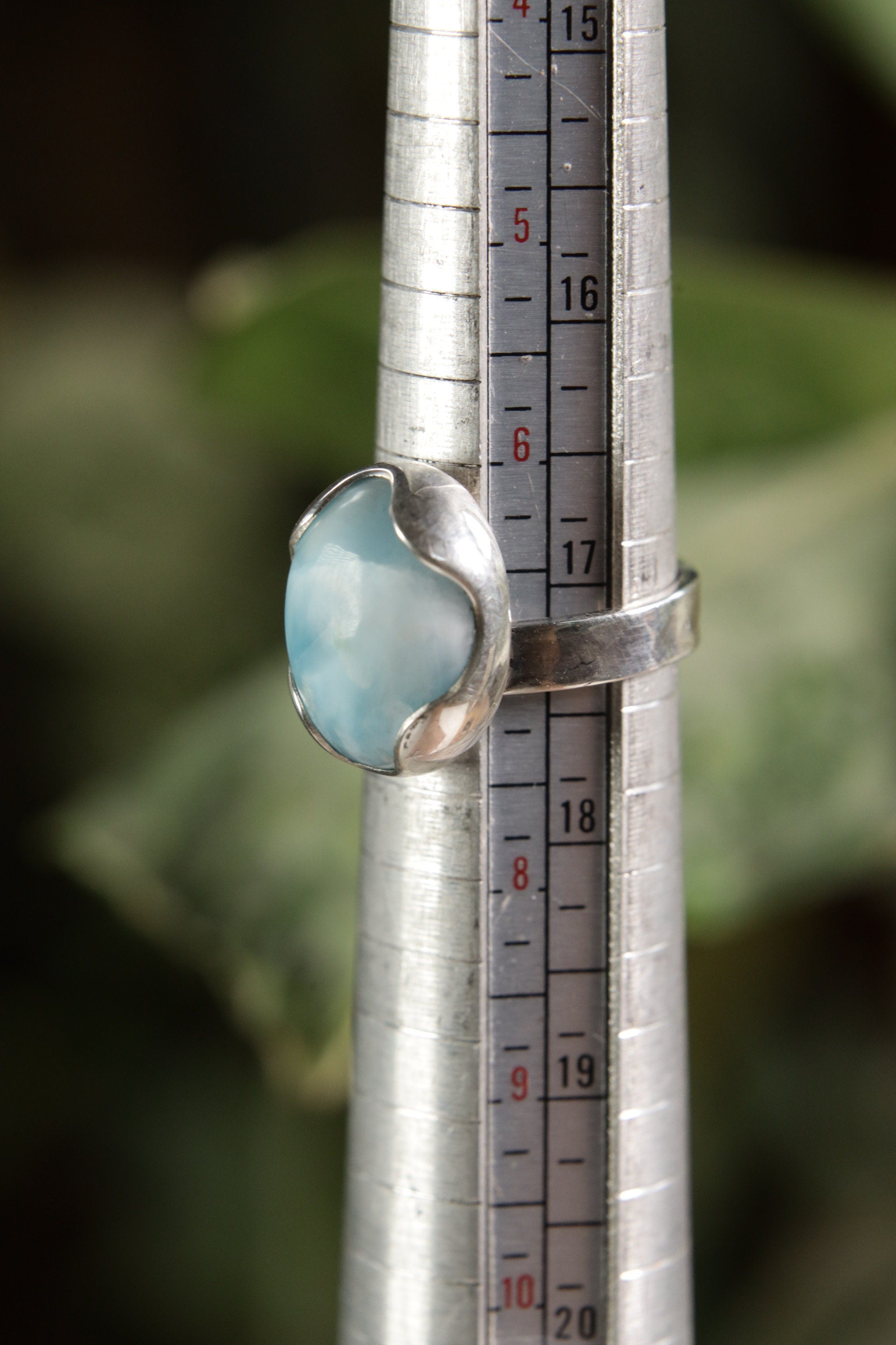Oval Larimar adjustable ring shown beside a ruler for scale, with high-shine 925 sterling silver and textured band.