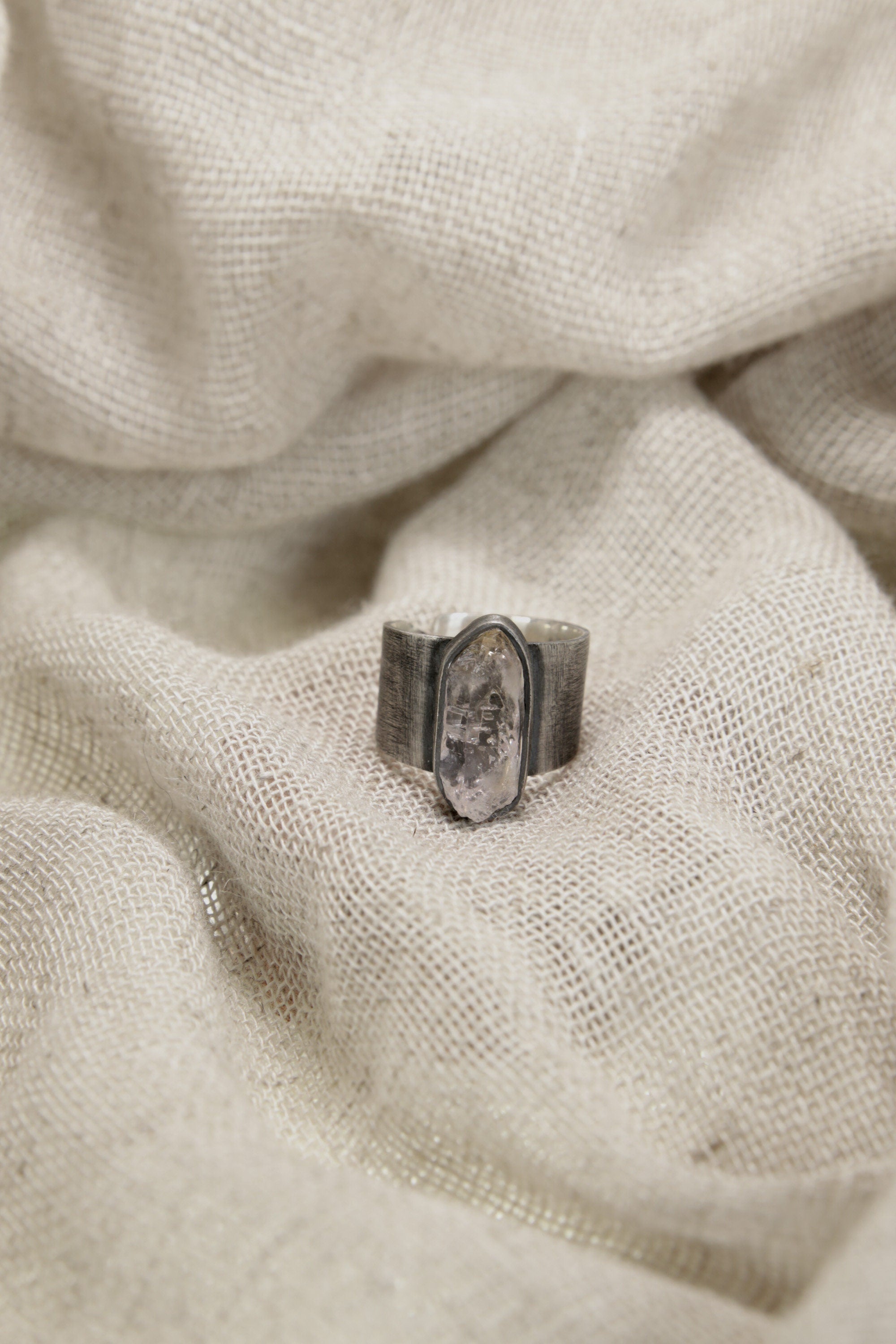 Vera Cruz Amethyst ring shown on soft fabric, with oxidized sterling silver and subtle twilight-purple crystal.