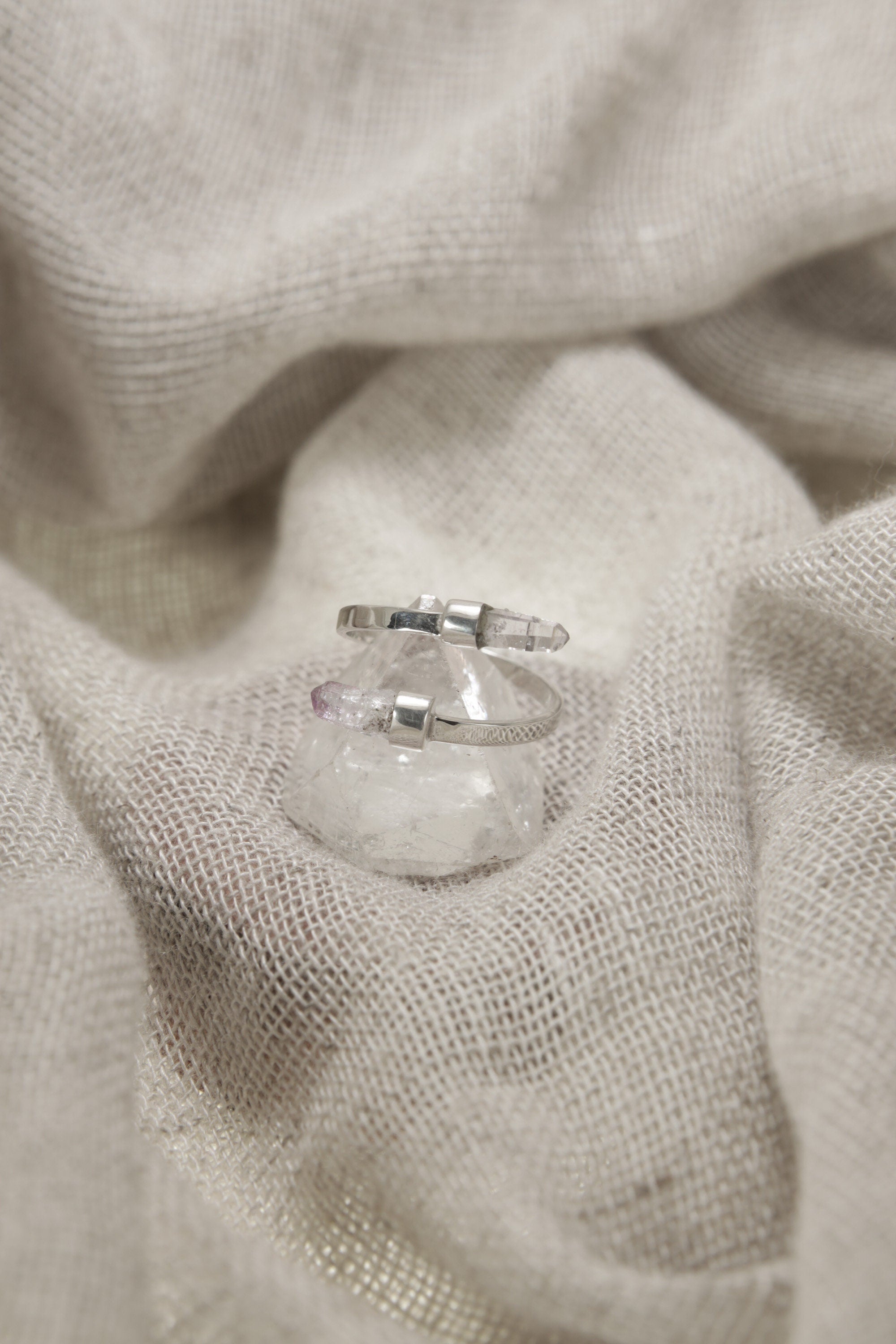 Amethyst Embrace Ring shown on fabric with open double-stone silver design and delicate Vera Cruz Amethyst.