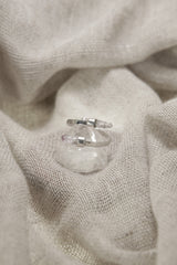 Amethyst Embrace Ring shown on fabric with open double-stone silver design and delicate Vera Cruz Amethyst.
