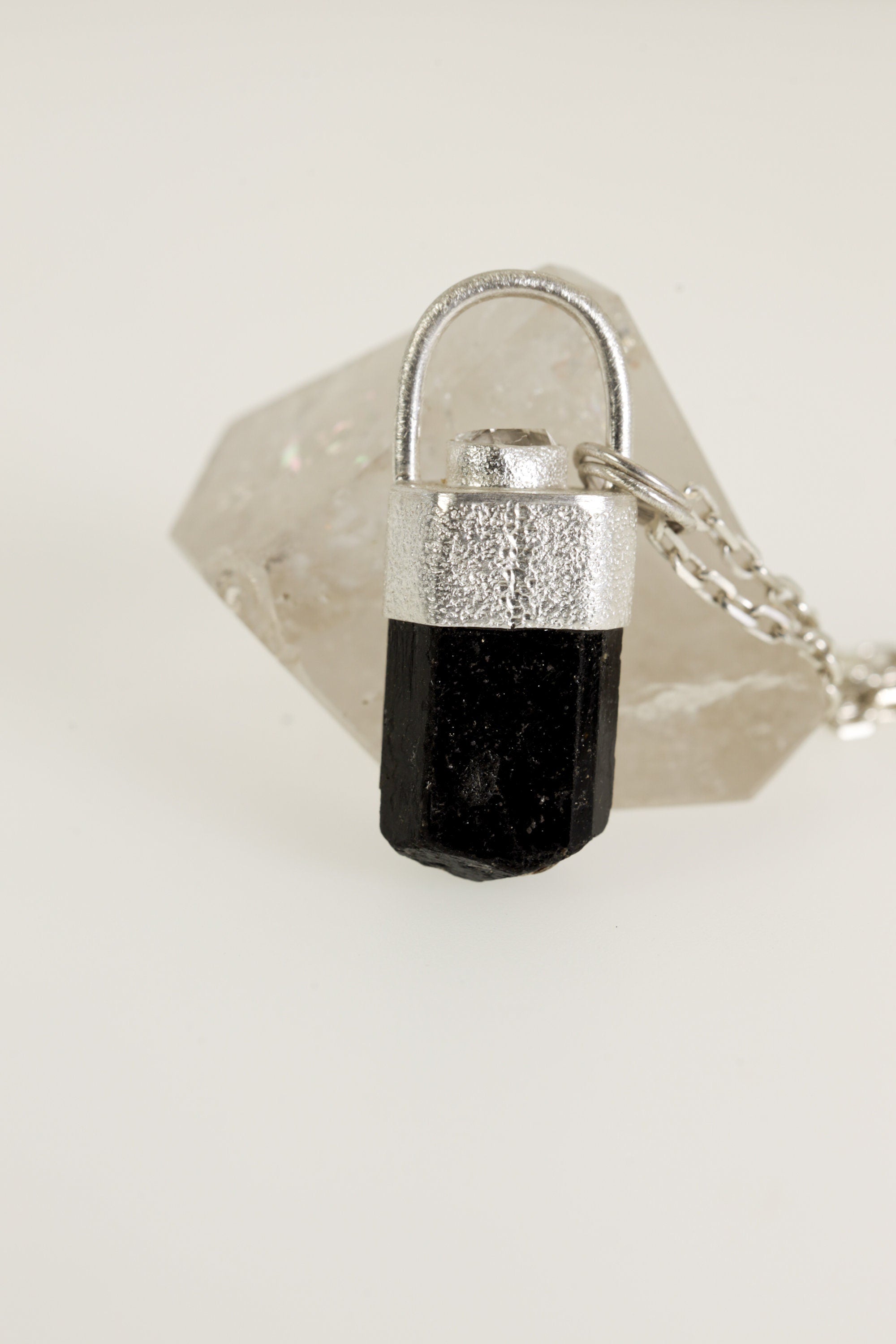Close-up of Brown Dravite Tourmaline pendant showing dark crystal body, sand-textured sterling silver, and Diamond accent.