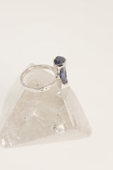Australian Ocean Kyanite ring displayed on clear quartz, showing oxidized silver band and vertical blue gemstone setting.