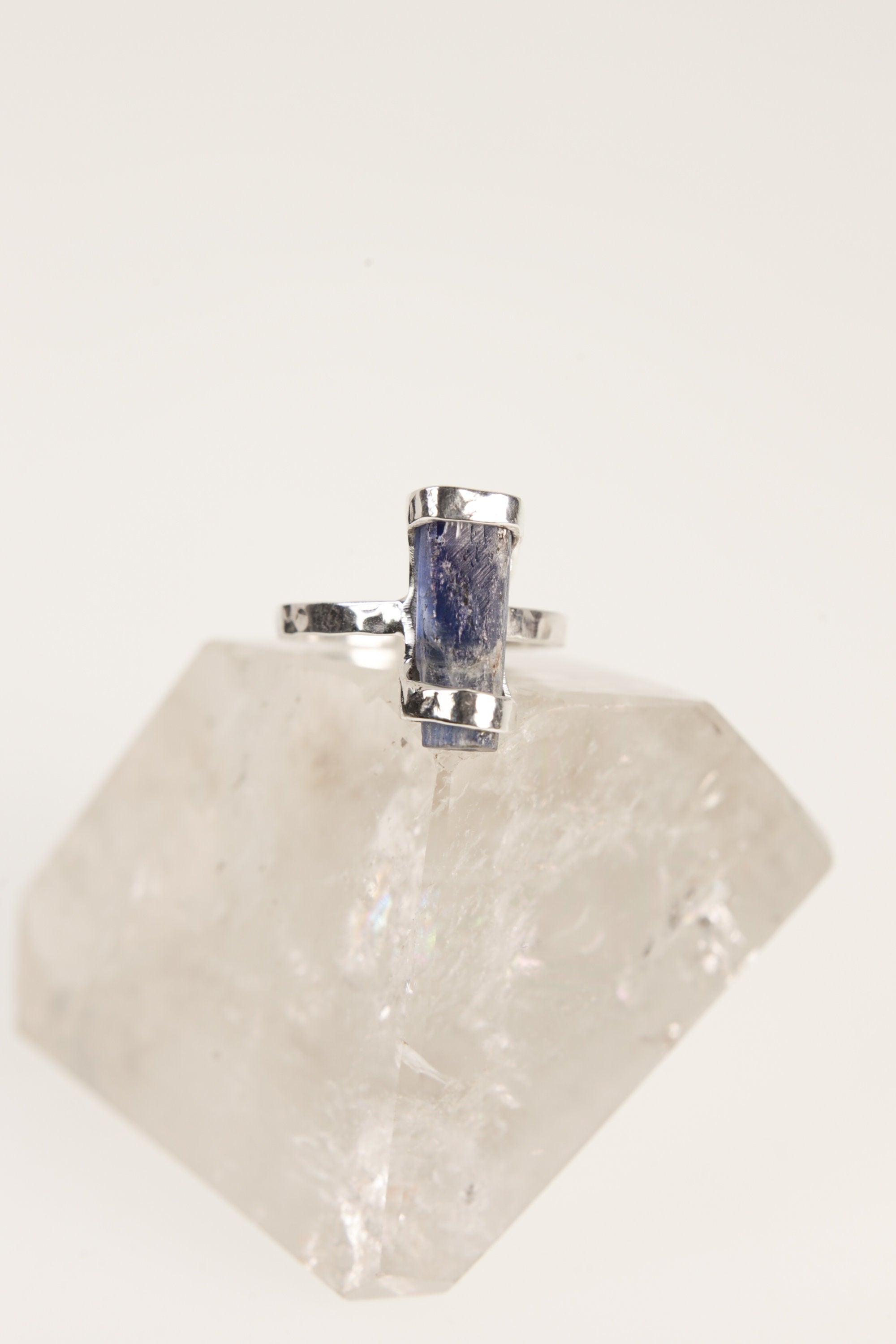 Oxidized sterling silver Ocean Kyanite ring shown on quartz, with hammered handmade band and deep blue stone.