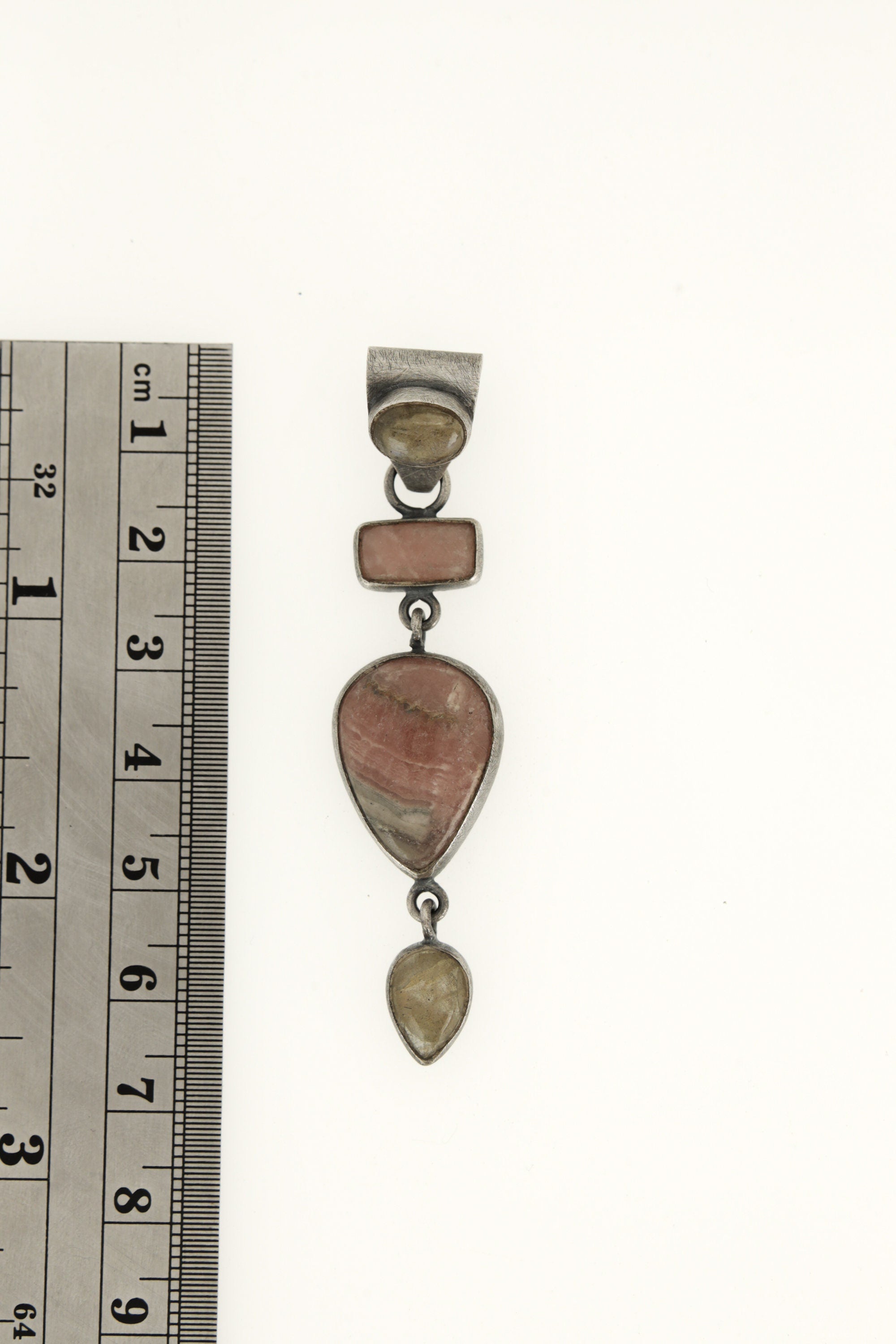 Moonstone Labradorite Rhodochrosite pendant shown beside a ruler for scale, with oxidized sterling silver and vertical stone arrangement.