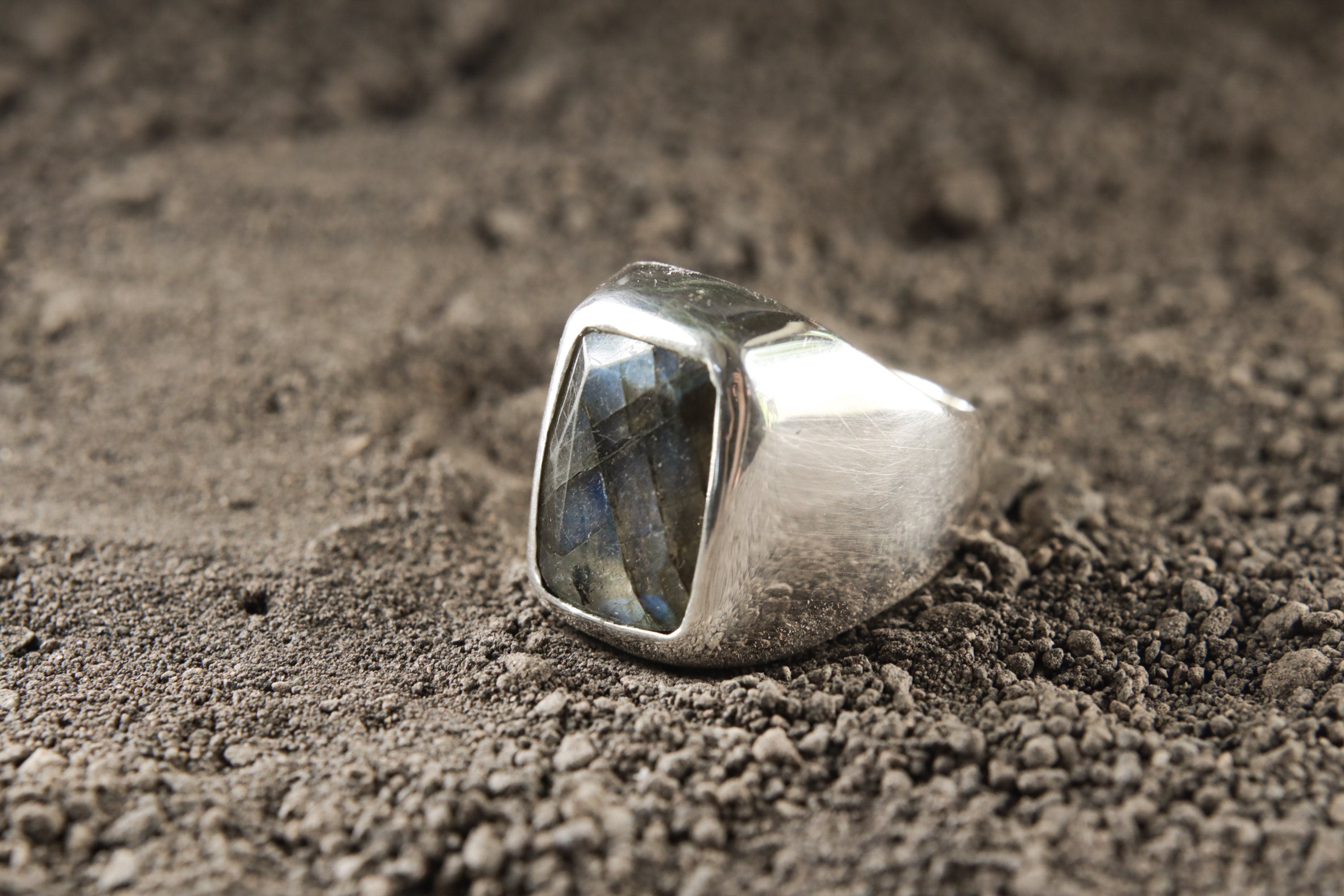 Side view of polished Labradorite ring showing the hollow sterling silver band and raised faceted gemstone setting.
