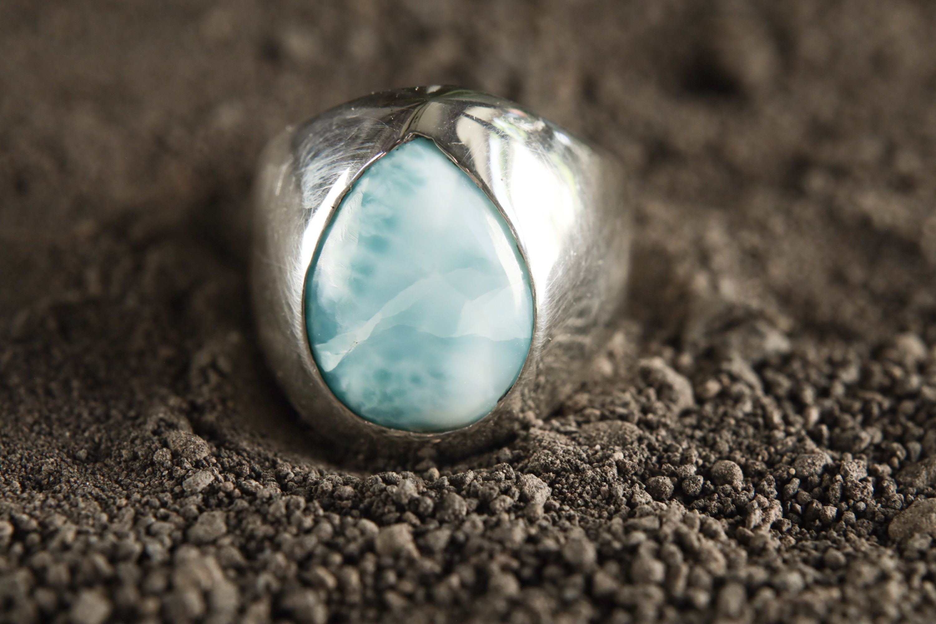 Close-up of Larimar cabochon ring showing soft blue colour, white ocean-like patterning, and polished sterling silver setting.