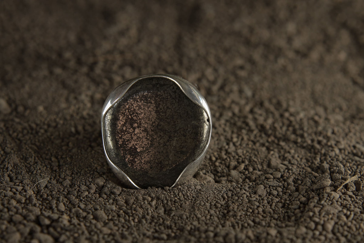 Pyrite adjustable ring in high-shine 925 sterling silver shown on earthy texture with metallic golden mineral surface.