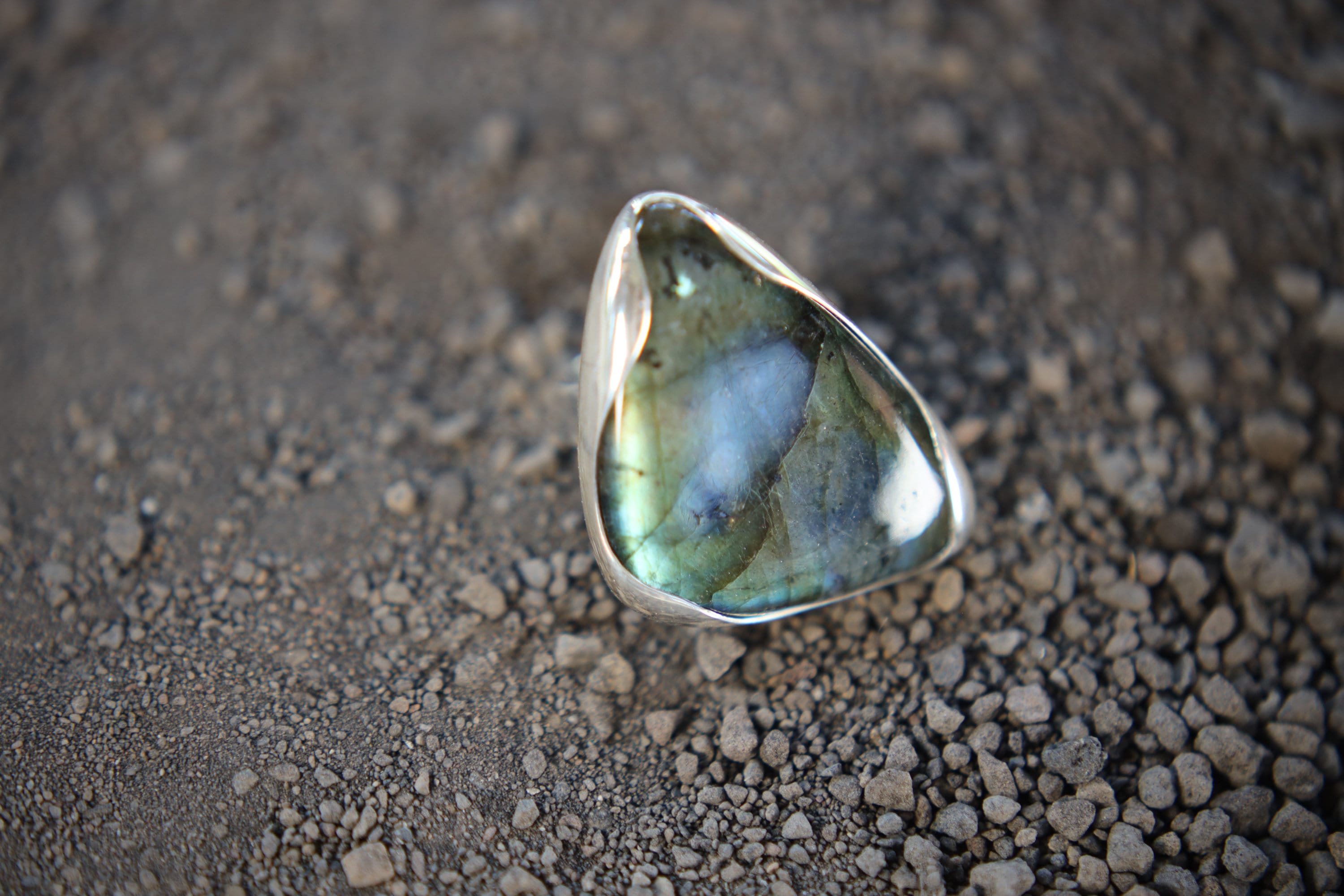 Triangular Labradorite adjustable ring in high-shine 925 sterling silver shown close-up with blue-green flash.