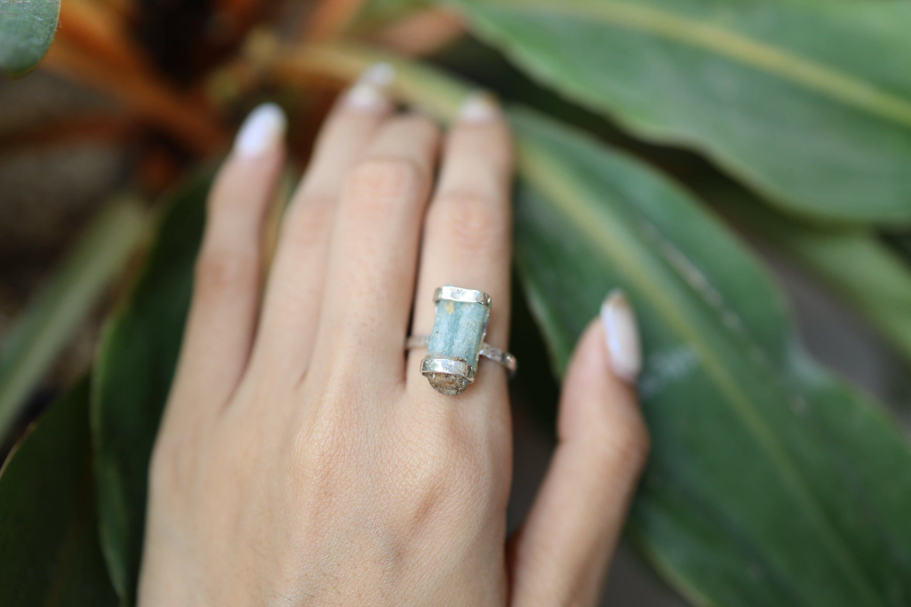 Raw Australian Aquamarine ring shown worn outdoors on a hand, with rugged oxidized silver and blue crystal detail.