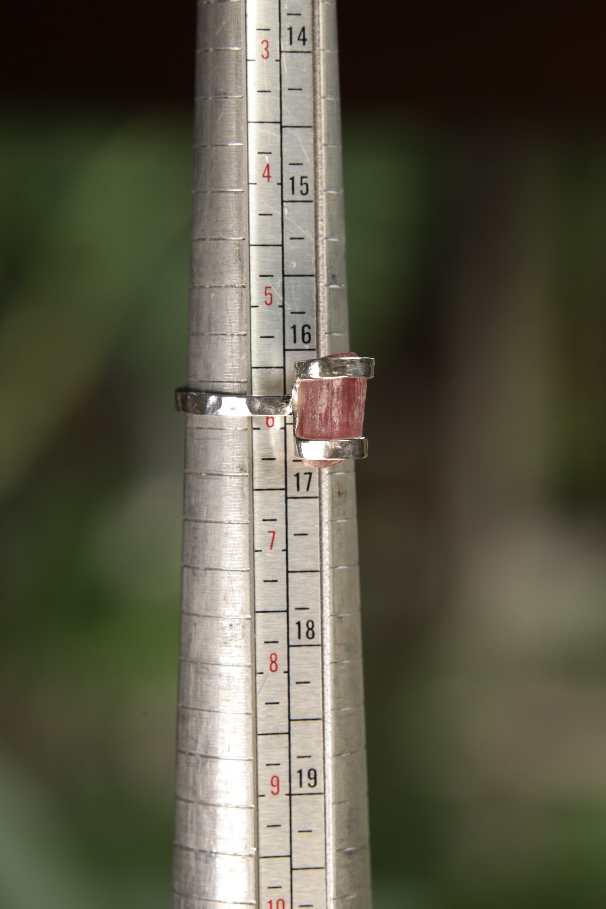Raw Pink Tourmaline sterling silver ring shown on a mandrel for size reference, appearing around US size 6 .