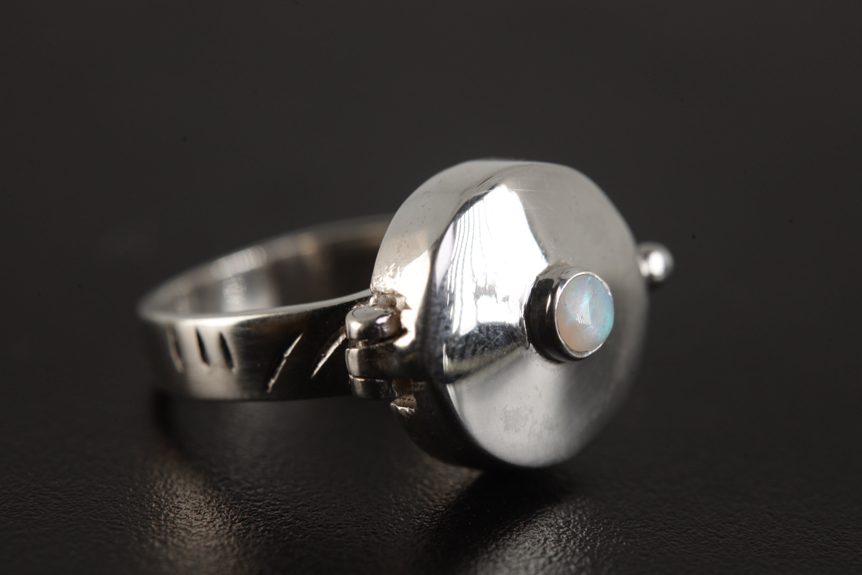 Opal Box Ring shown on black background with high-polish sterling silver box top and sculptural ring form.