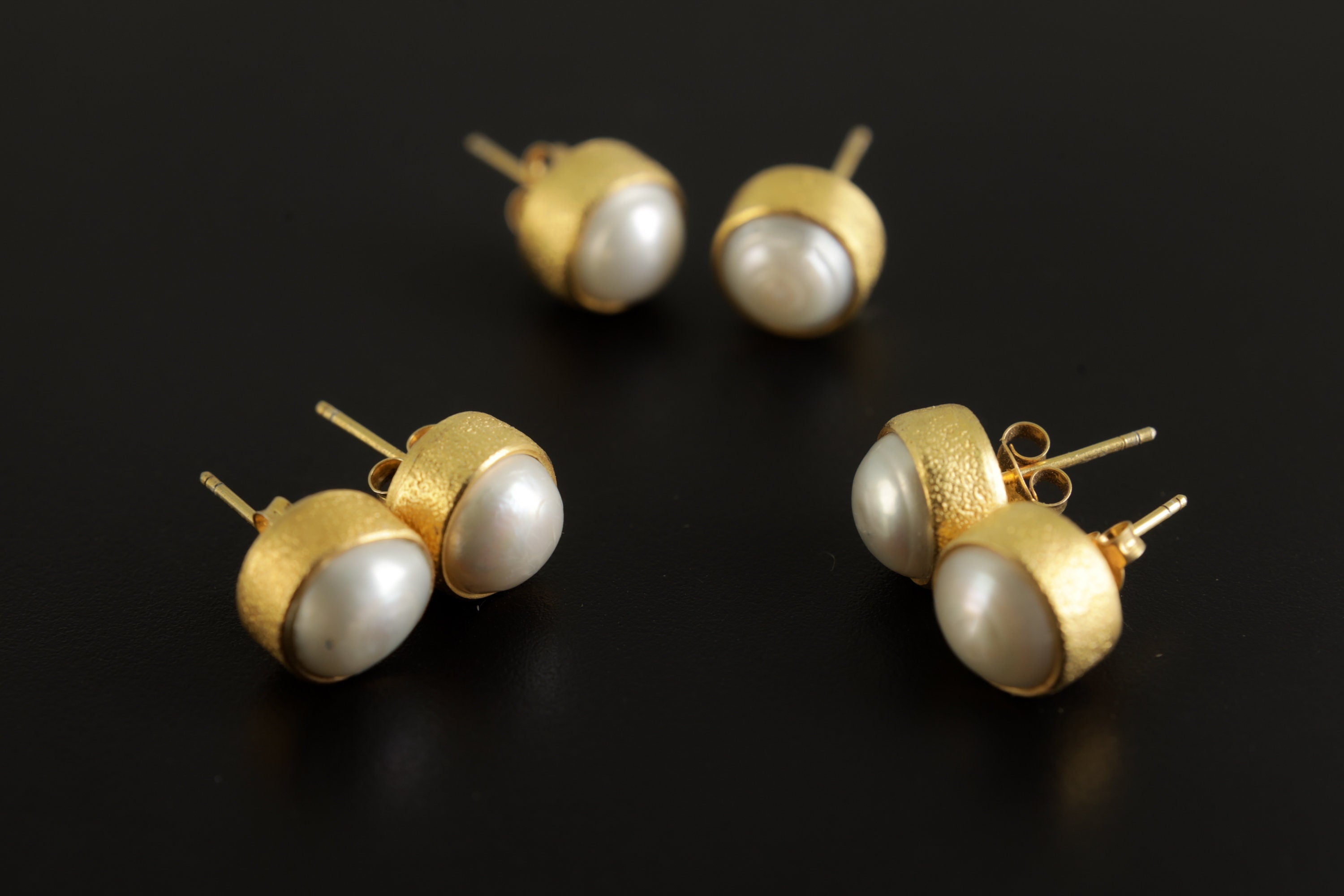 Group of handmade South Sea Pearl stud earrings showing natural pearl variation and 16k gold-plated silver settings.