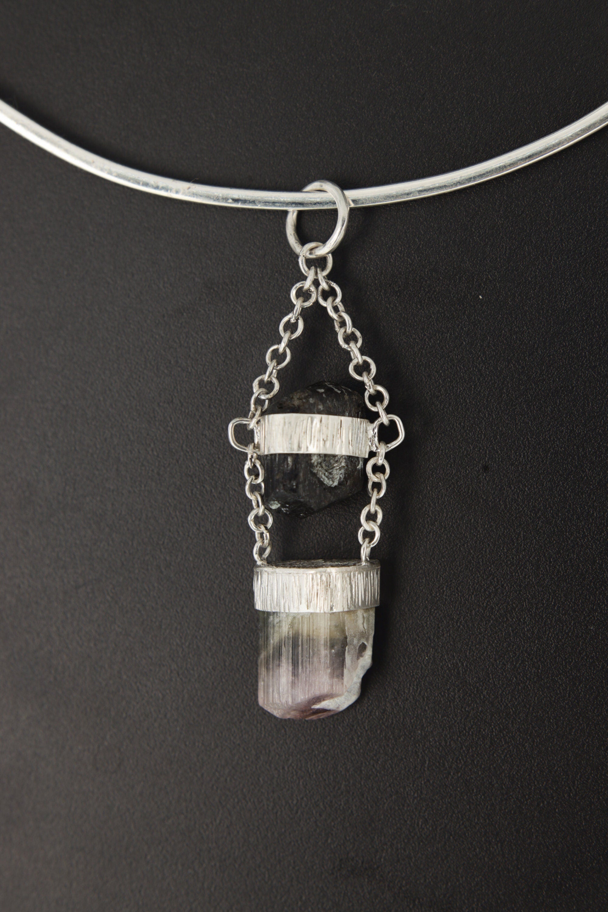 Black Tourmaline Watermelon Tourmaline pendant shown on a black background with specialty chain and polished silver setting.