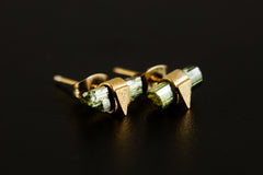 Handmade Green Tourmaline stud earrings displayed on dark background with raw stones and triangle settings.