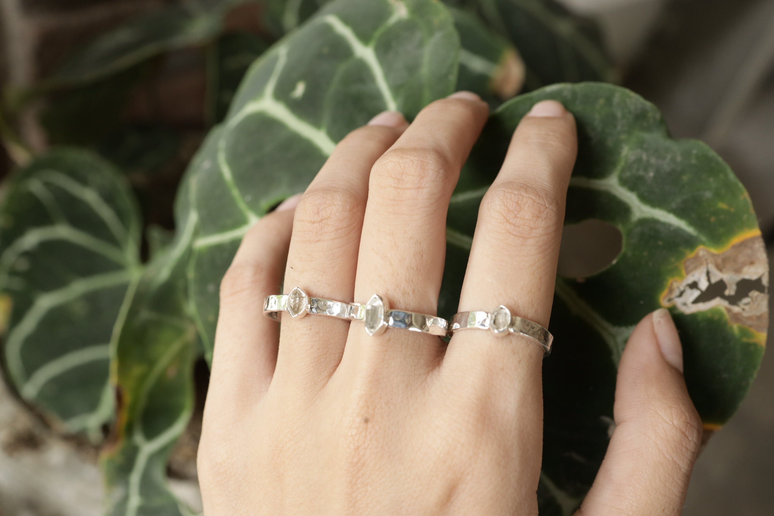 Petite Herkimer Diamond Ring shown worn outdoors with raw clear Quartz crystal and hammered silver texture.