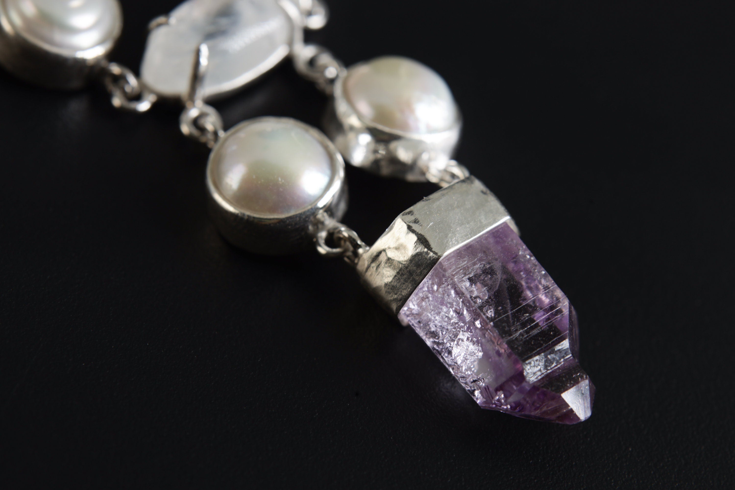 Close-up of South Sea Pearls, Cat’s Eye Moonstone, and Vera Cruz Amethyst point in a 925 sterling silver pendant.