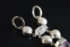 Close-up of dual-sided round bail and South Sea Pearl settings in a hammered high-shine sterling silver pendant.