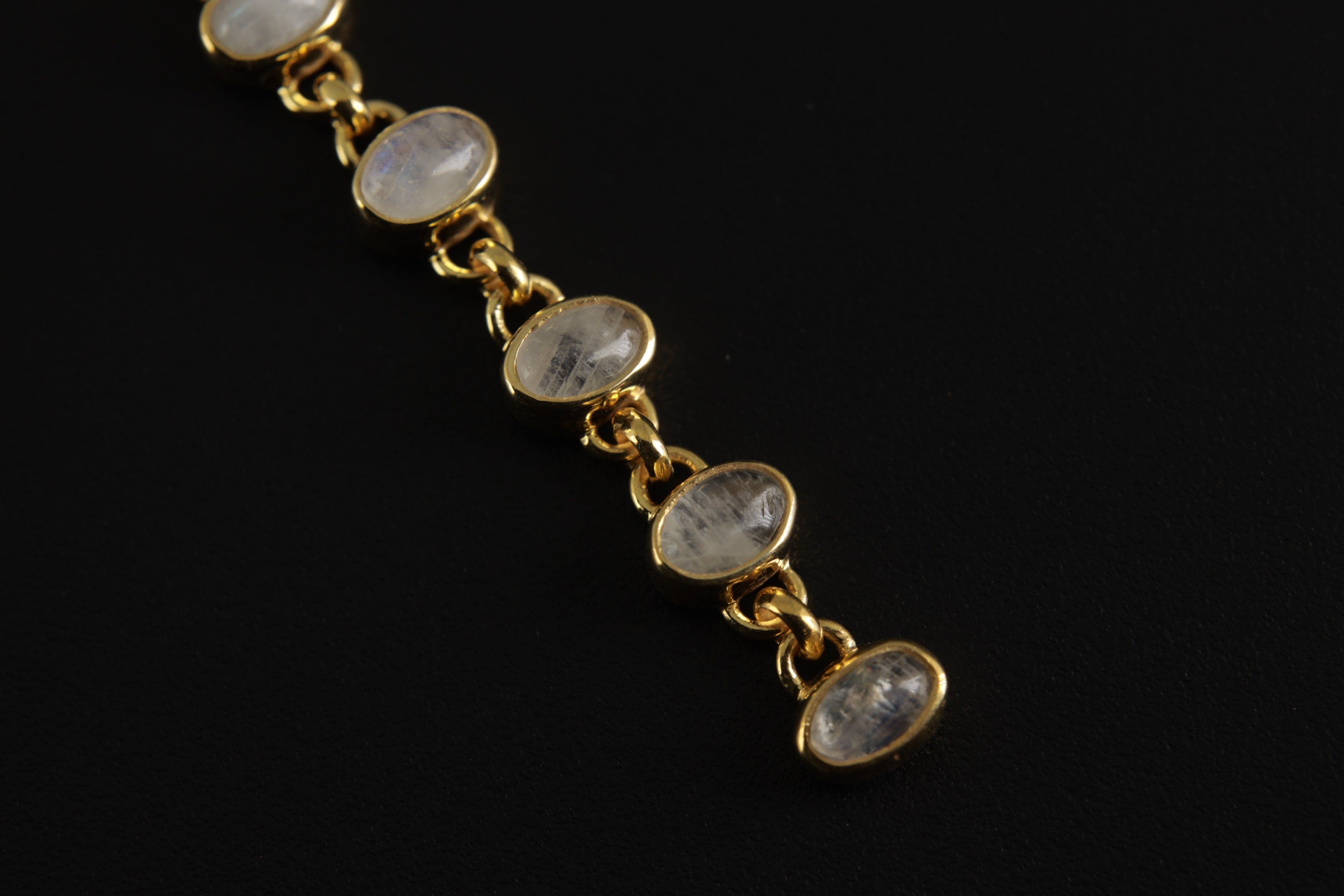 Luminous Amulet Under Moonlight pendant shown close-up with oval Rainbow Moonstones and gold-plated silver links.
