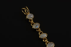 Close-up of Rainbow Moonstone pendant showing oval bezel-set stones and warm 18k gold-plated silver.