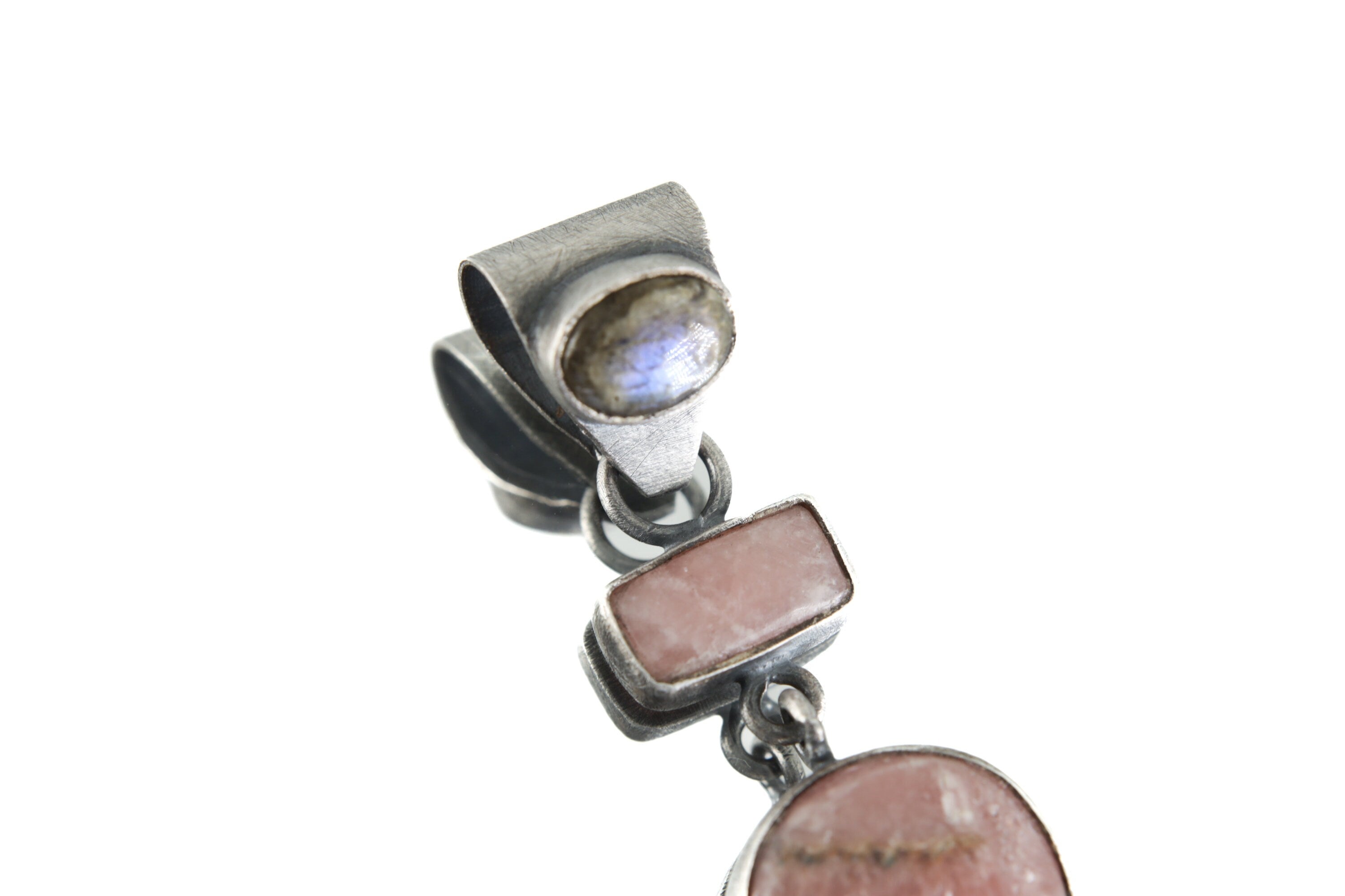 Close-up of oxidized sterling silver pendant with Moonstone, Labradorite, and Rhodochrosite, showing brushed texture and layered stone setting.