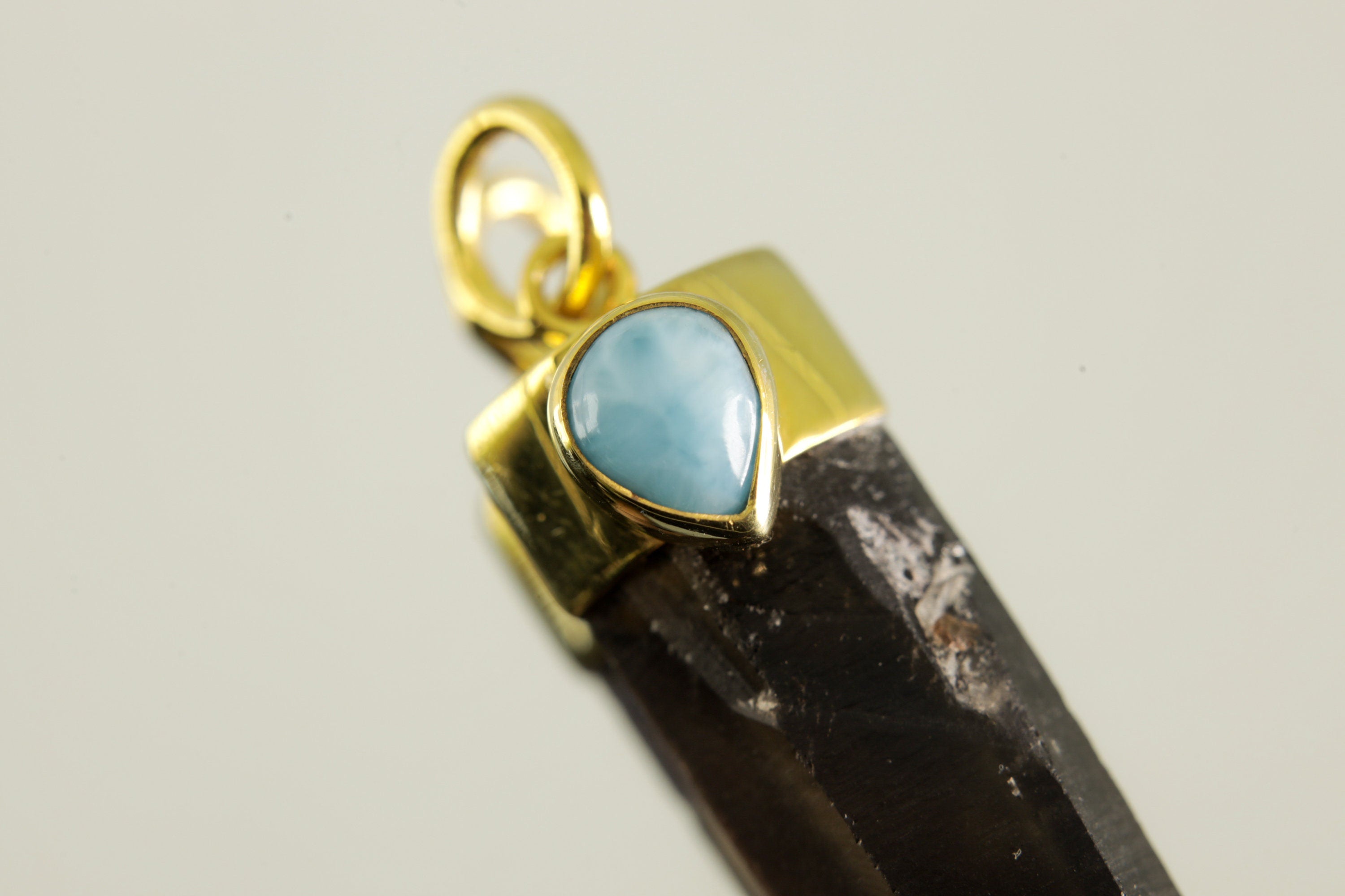 Detailed view of Larimar cabochon set into gold-plated sterling silver cap above Smoky Phantom Quartz point.