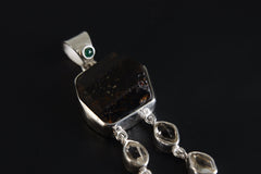 Close-up of round Emerald accent and Dravite Tourmaline in a hammered polished sterling silver statement pendant.