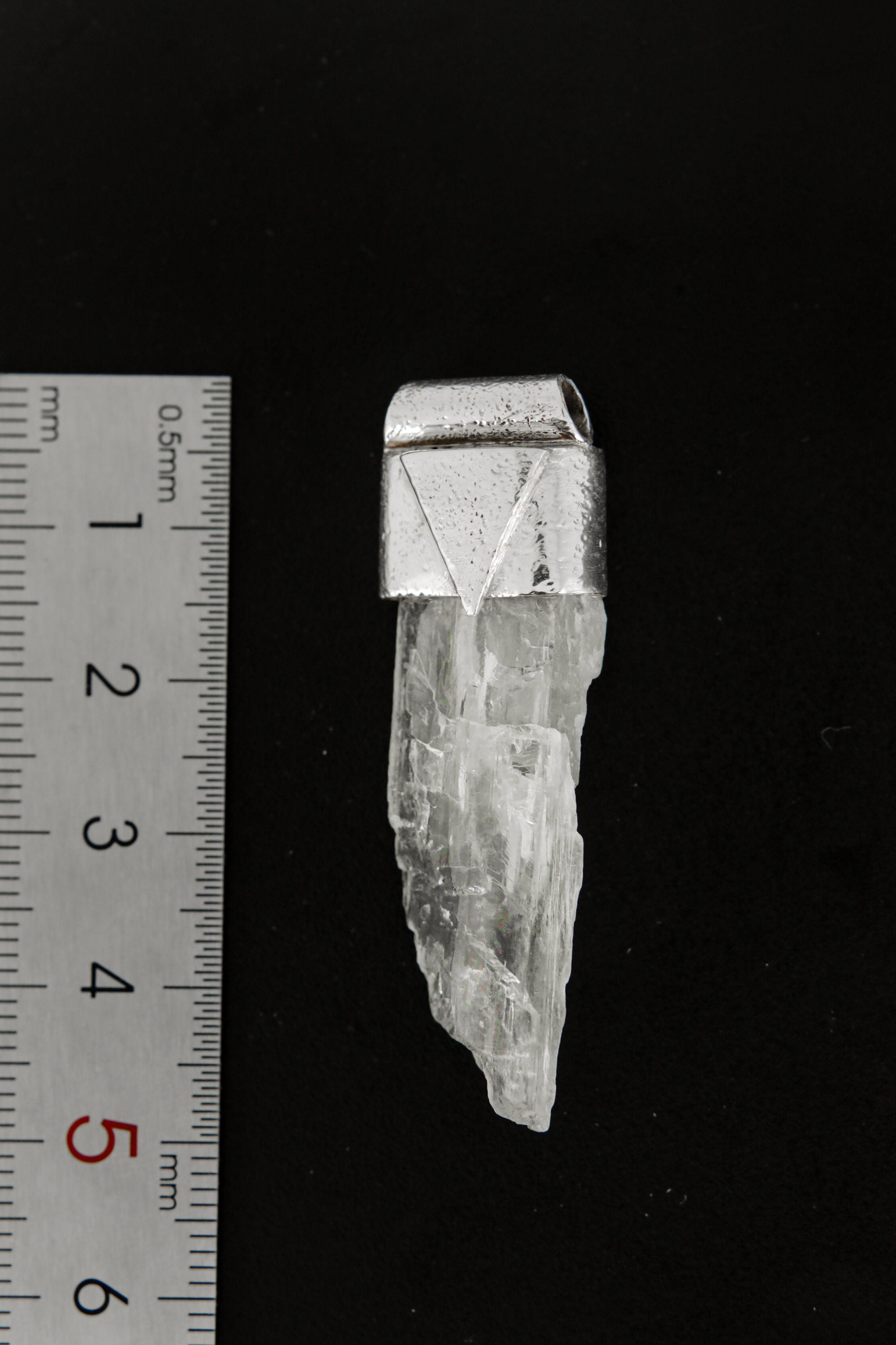 Hiddenite Stack Pendant shown beside a ruler for scale, measuring approximately 5 cm long.