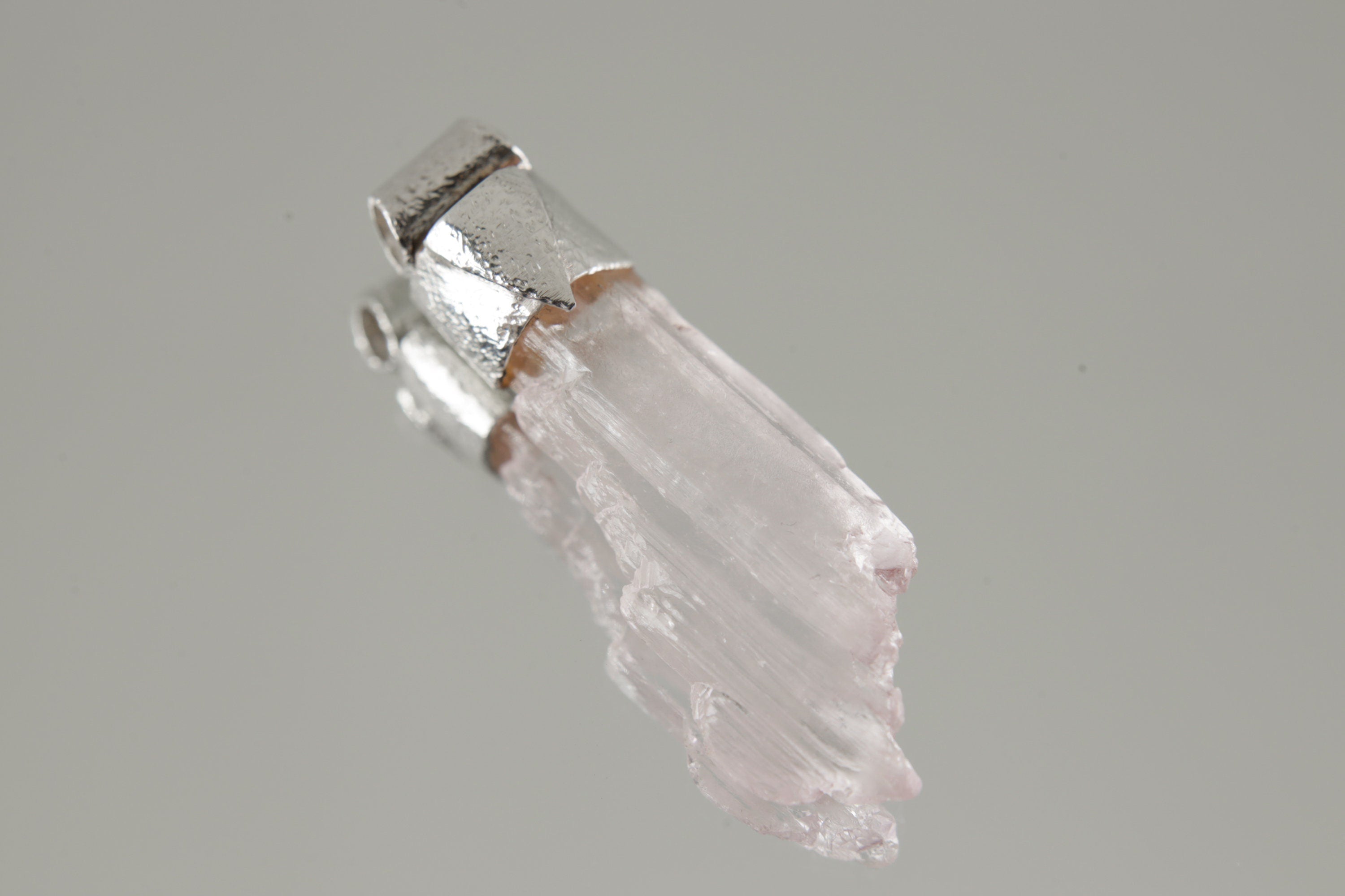 Specimen Crystal Stack Pendant shown on light background with organic textured sterling silver cap and raw crystal formation.