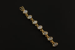 Seven Rainbow Moonstone gold-plated sterling silver pendant shown on dark background with long linked lunar design.