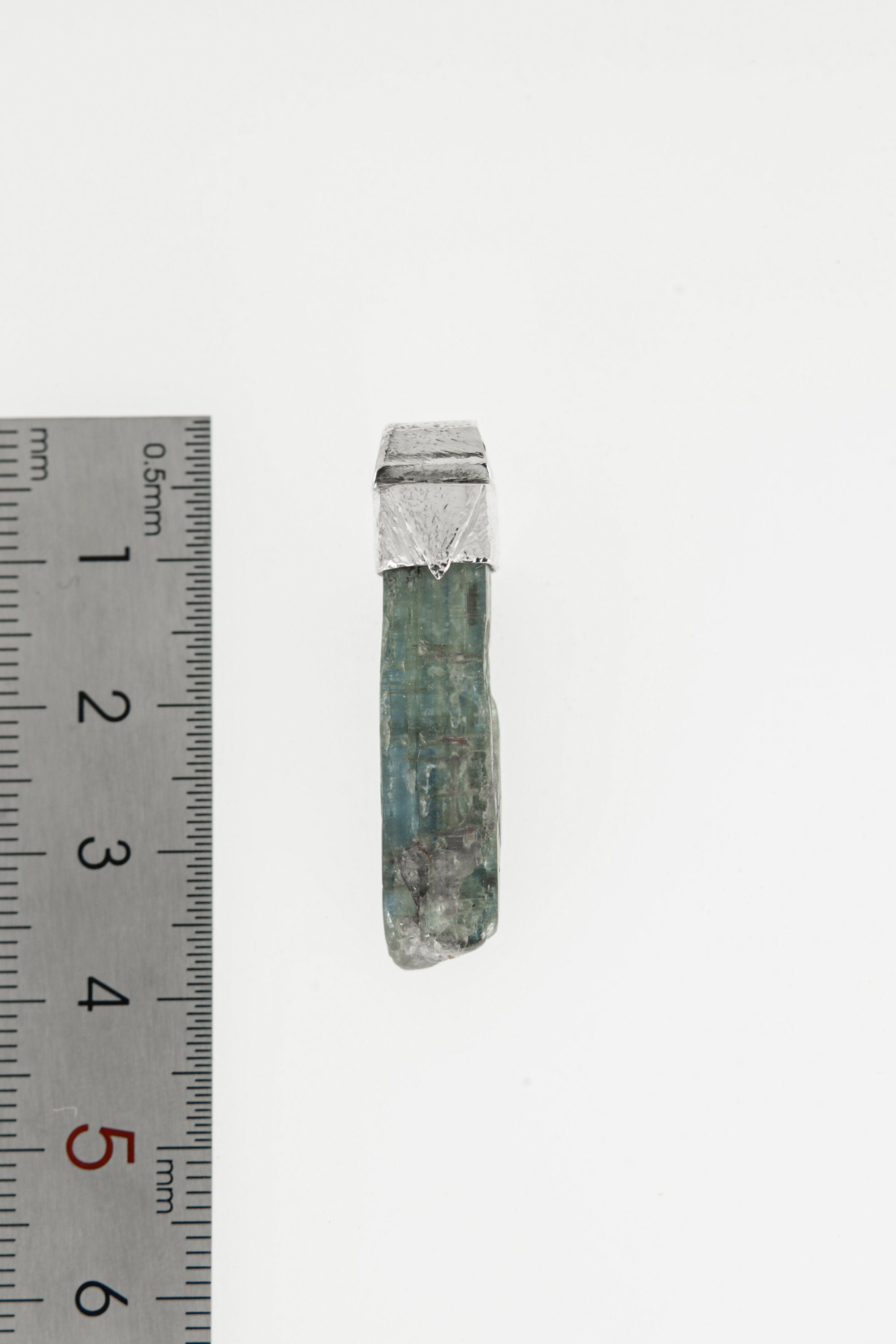 Kyanite Stack Pendant shown beside a ruler for scale with 925 silver cap and blue crystal body.
