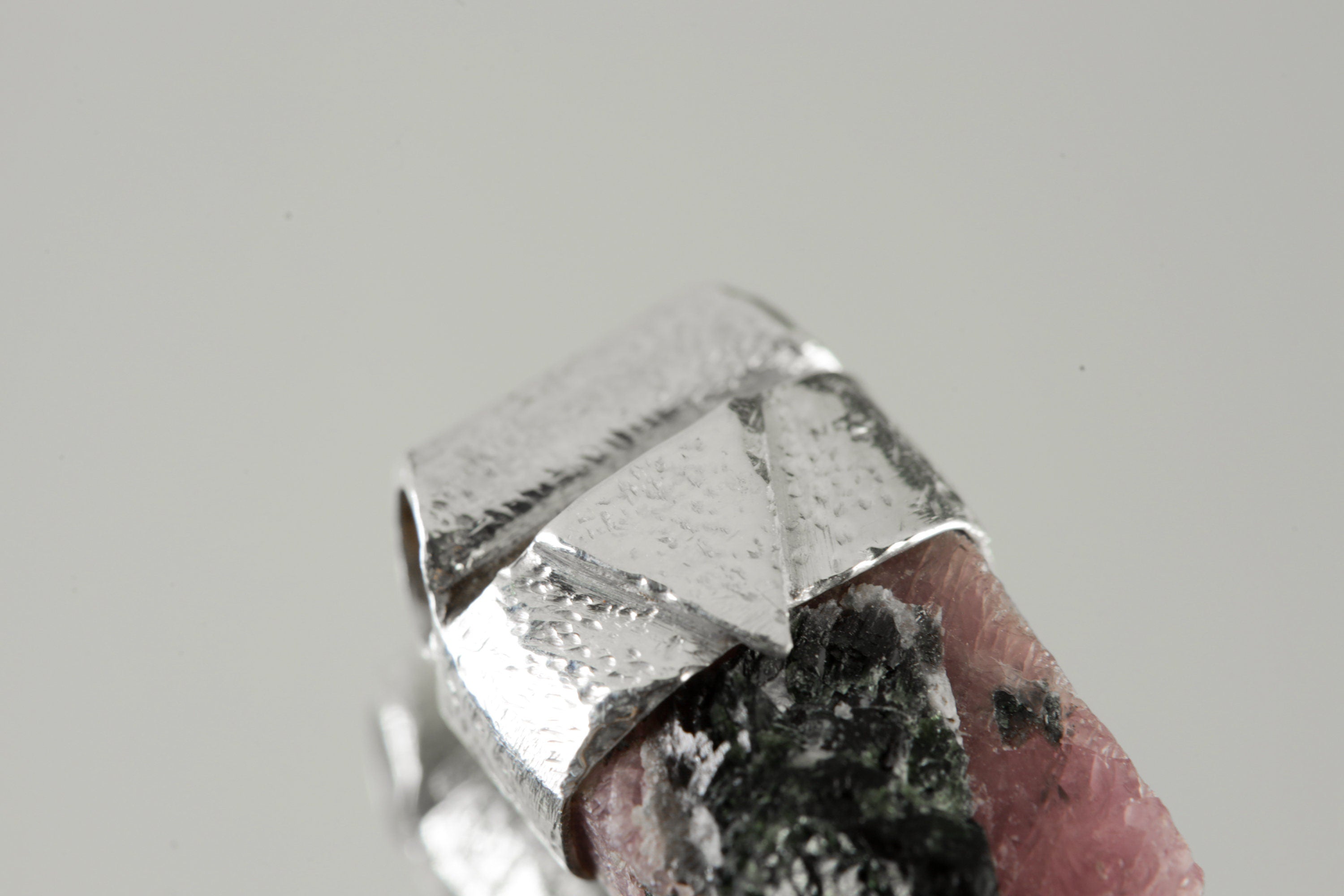 Close-up of raw Hexagonal Ruby with Black Mica in a handmade textured sterling silver Stack Pendant cap.