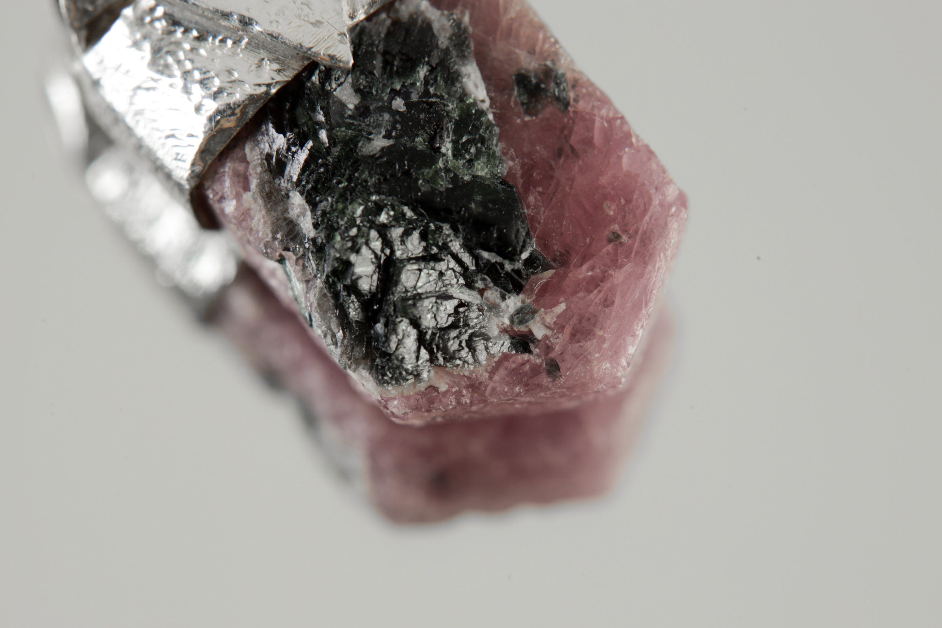 Close-up of Ruby with Black Mica showing red corundum texture, dark mica inclusions, and organic sterling silver cap.