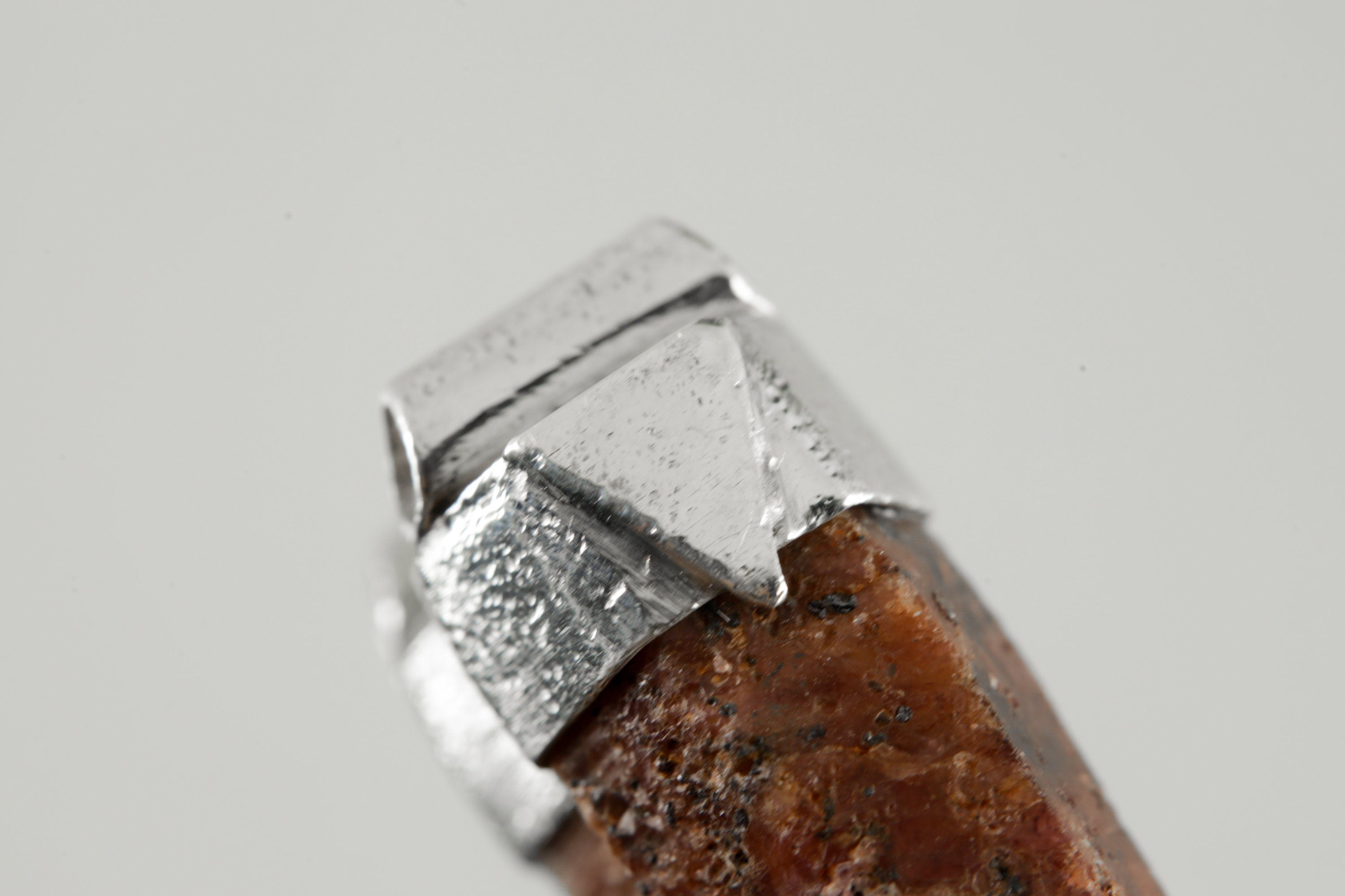 Close-up of raw Hexagonal Ruby specimen in a handmade textured sterling silver Stack Pendant cap.