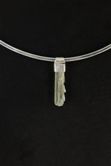Skeletal Aquamarine Stack Pendant shown on black background with hand-hammered silver cap and slim raw crystal.