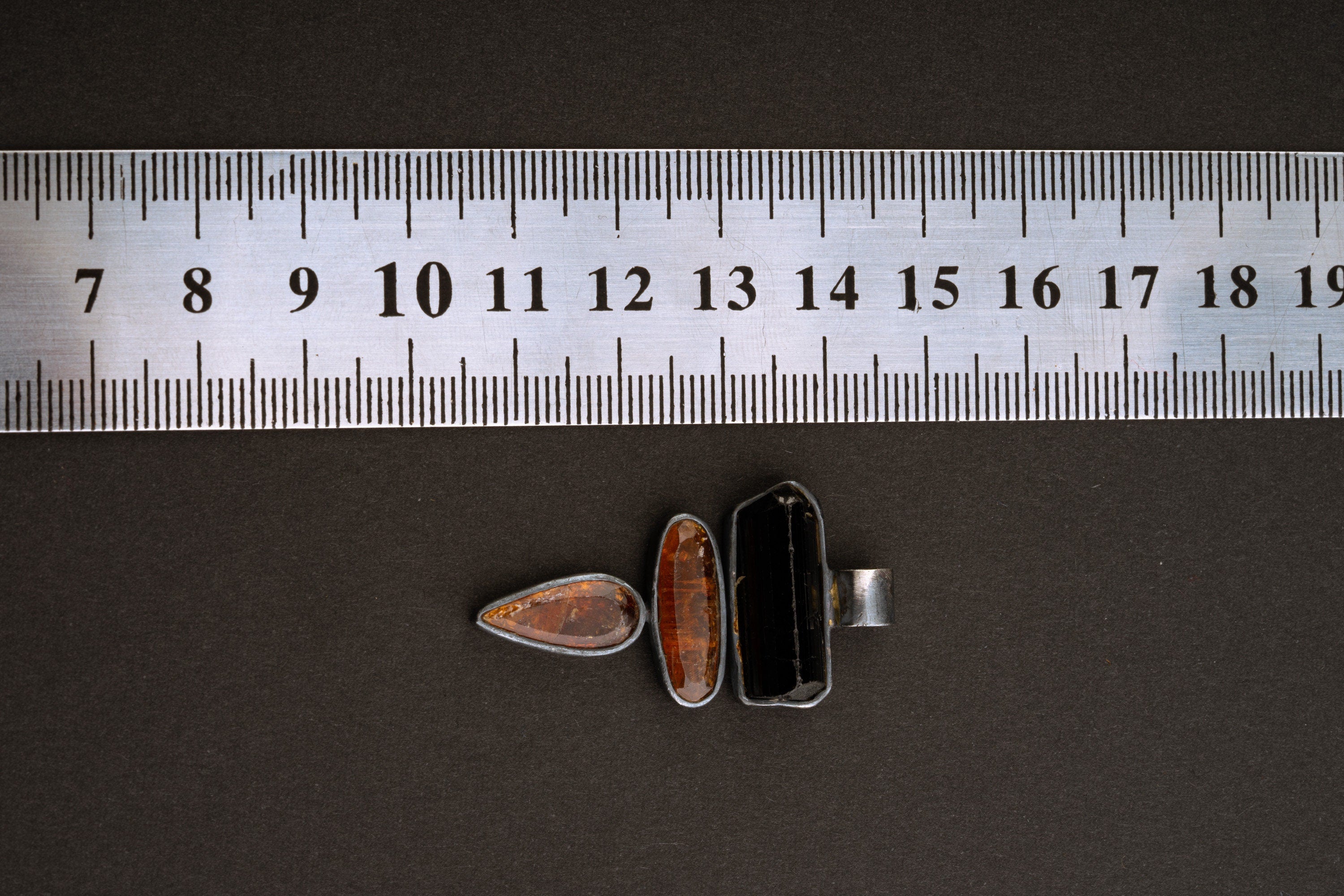 Black Tourmaline Red Kyanite sterling silver pendant shown beside a ruler for scale with triple bezel design.