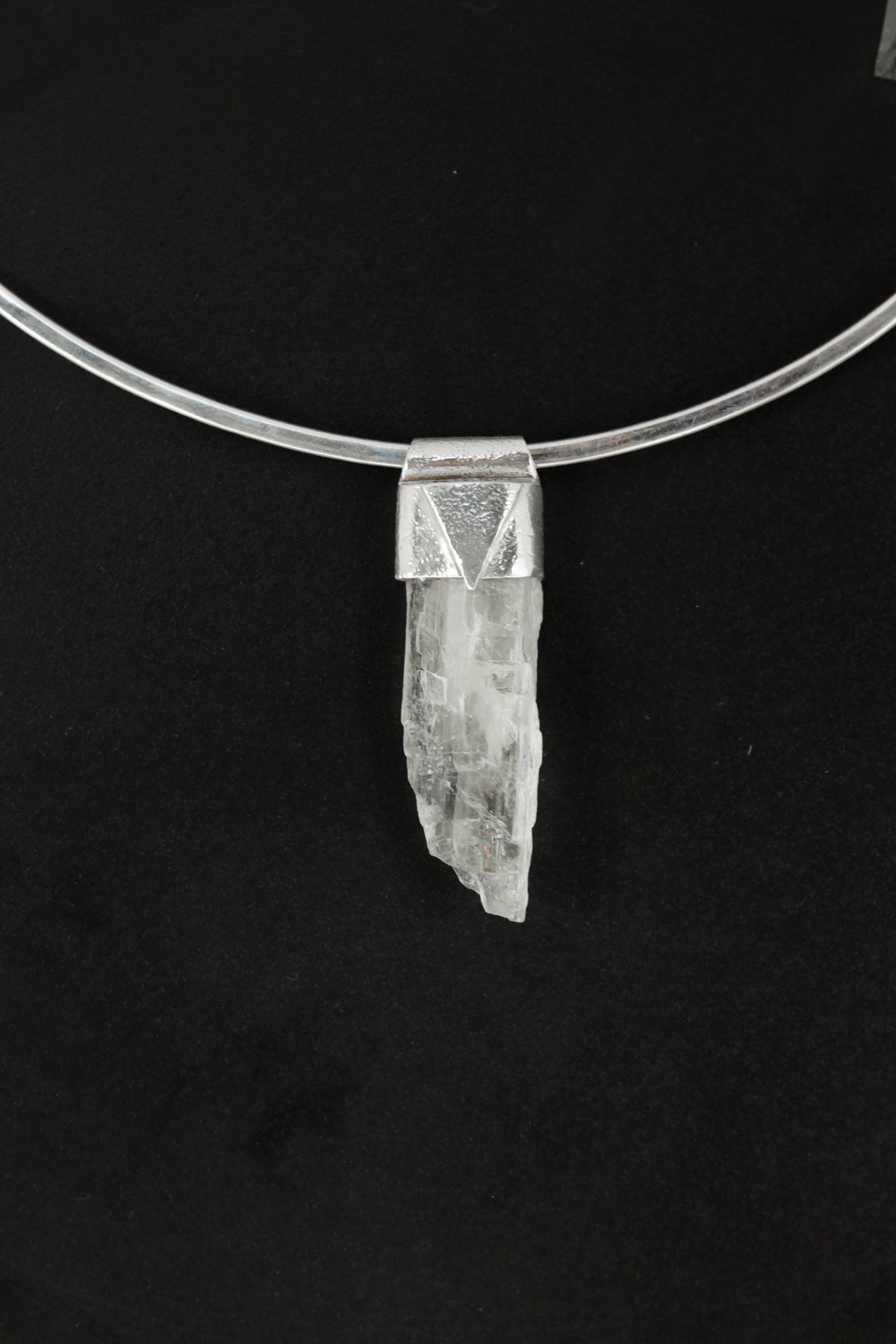 Hiddenite Stack Pendant shown on black background with sterling silver cap and pale green Spodumene crystal.