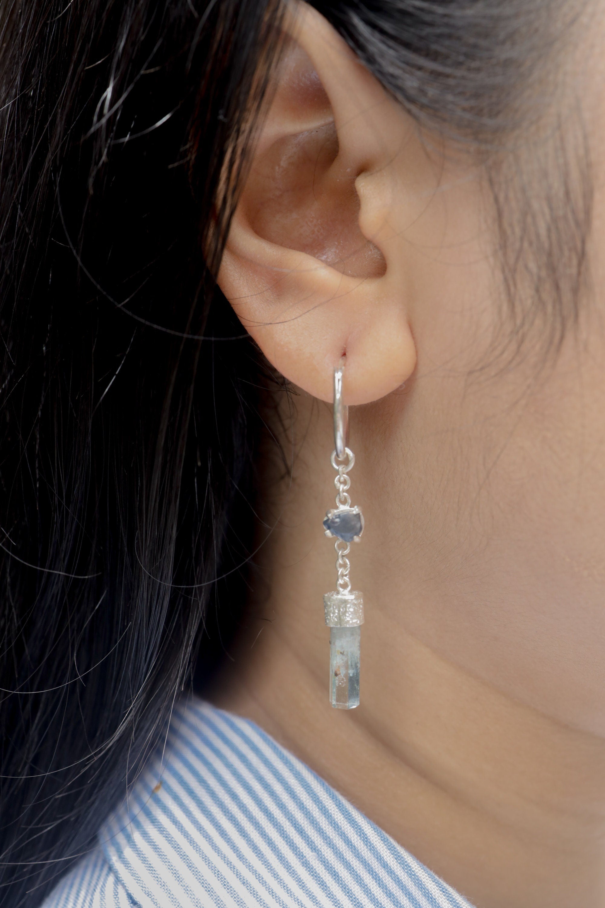 Sapphire Aquamarine earrings shown worn on a model, with sterling silver hook fittings and cascading blue gemstone drops.