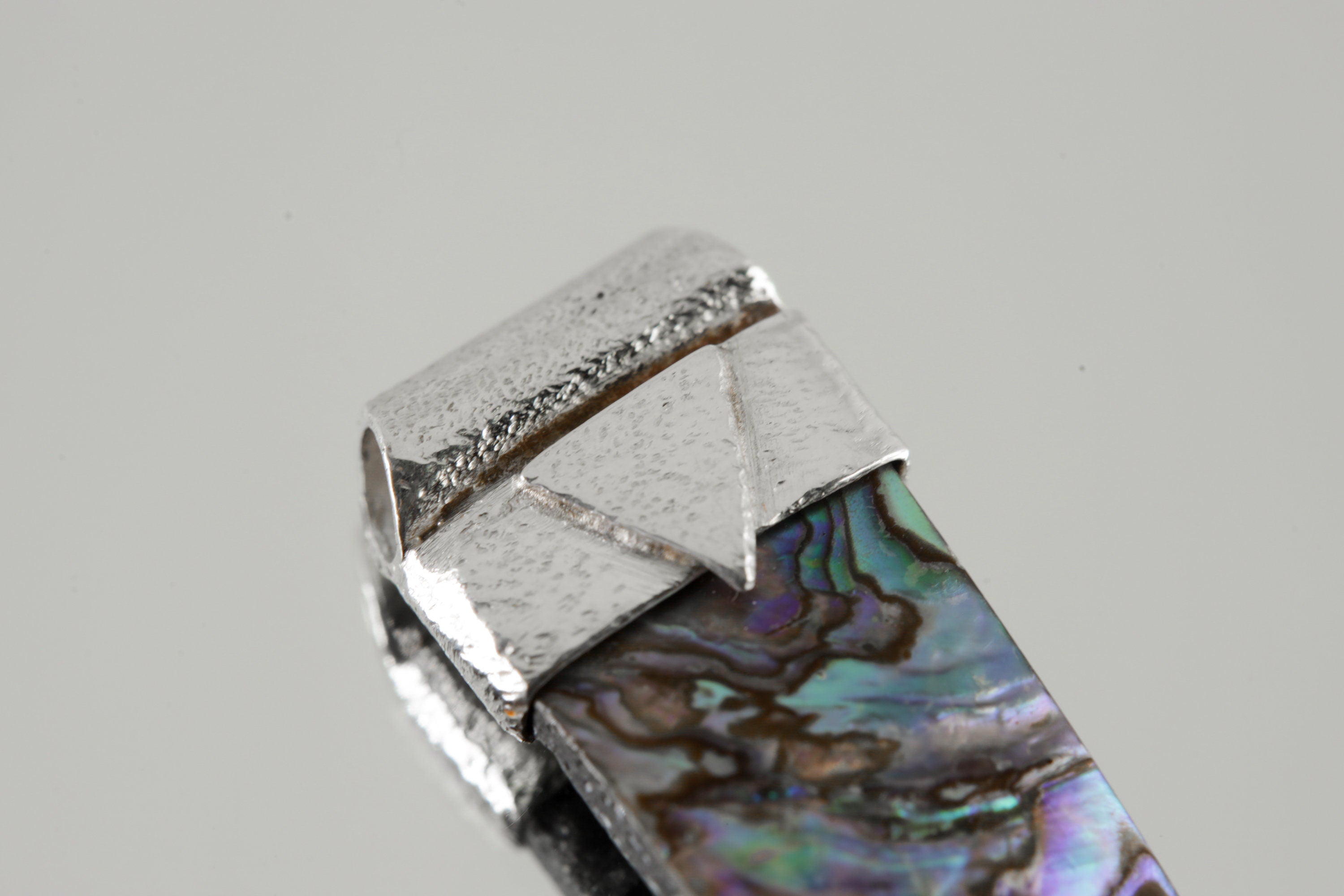 Close-up of Mother of Pearl in a handmade sterling silver Stack Pendant cap with signature triangle detail.