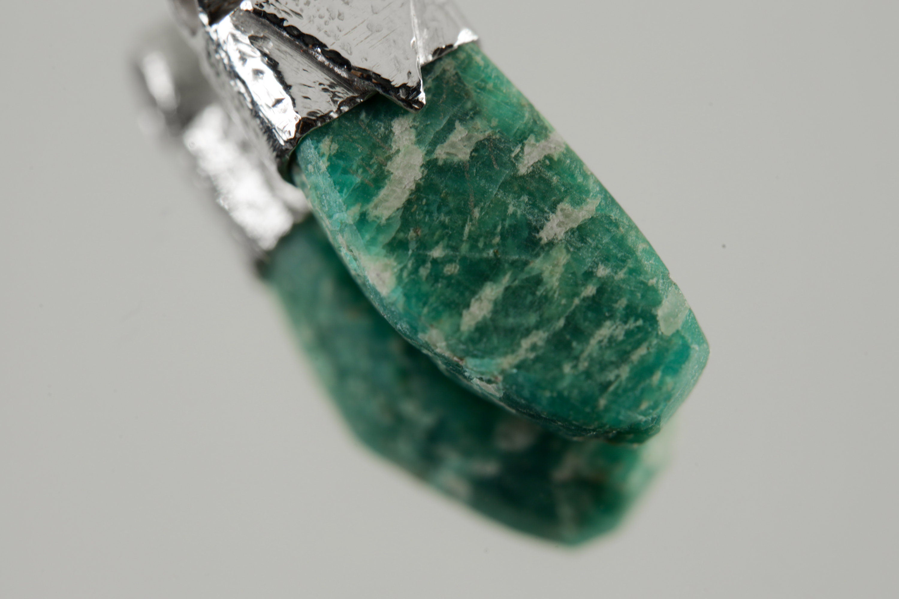 Close-up of Rough Cut Amazonite in a handmade sterling silver Stack Pendant cap with signature triangle detail.