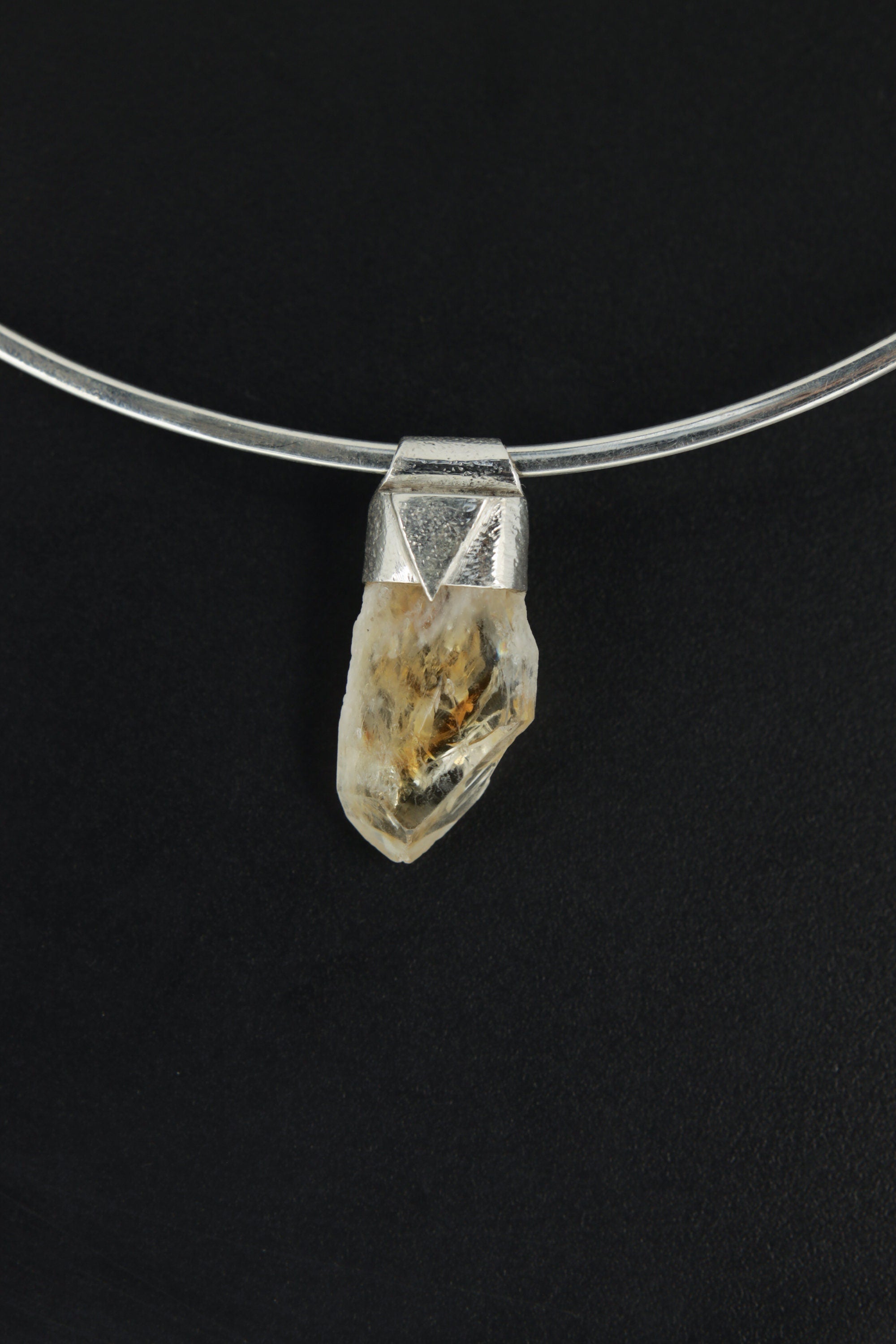 Natural Phantom Citrine Quartz Stack Pendant shown on black background with silver choker and golden crystal point.