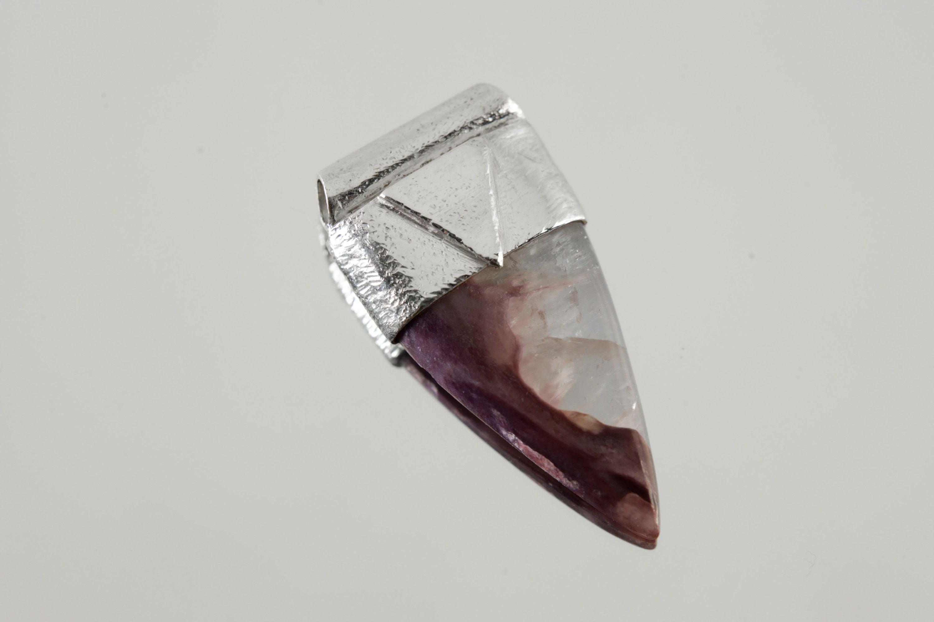 Fang Shaped Charoite Stack Pendant shown on light background with polished purple stone and textured silver cap.