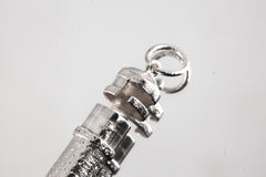 Close-up of sterling silver capsule pendant showing sand-textured surface, round bail, and opening mechanism.