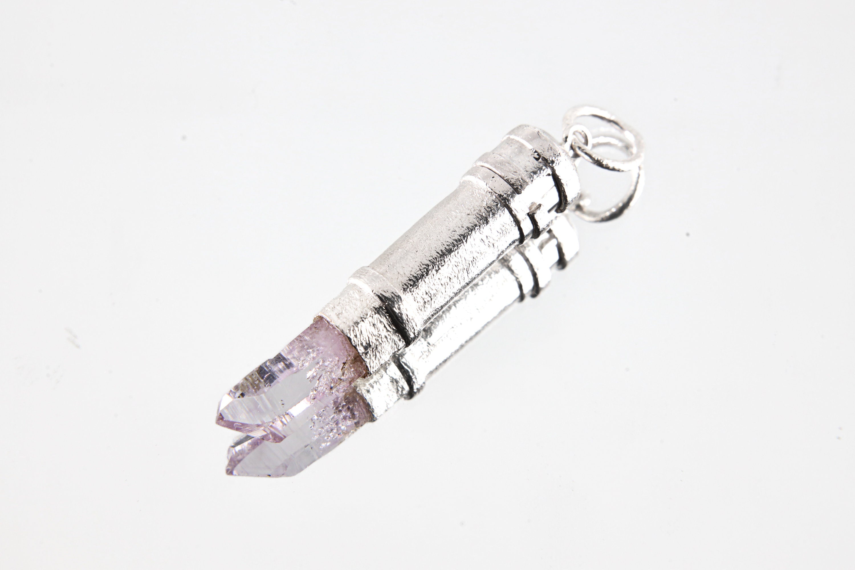 Vera Cruz Amethyst capsule pendant shown on white background with polished 925 sterling silver and raw crystal point.