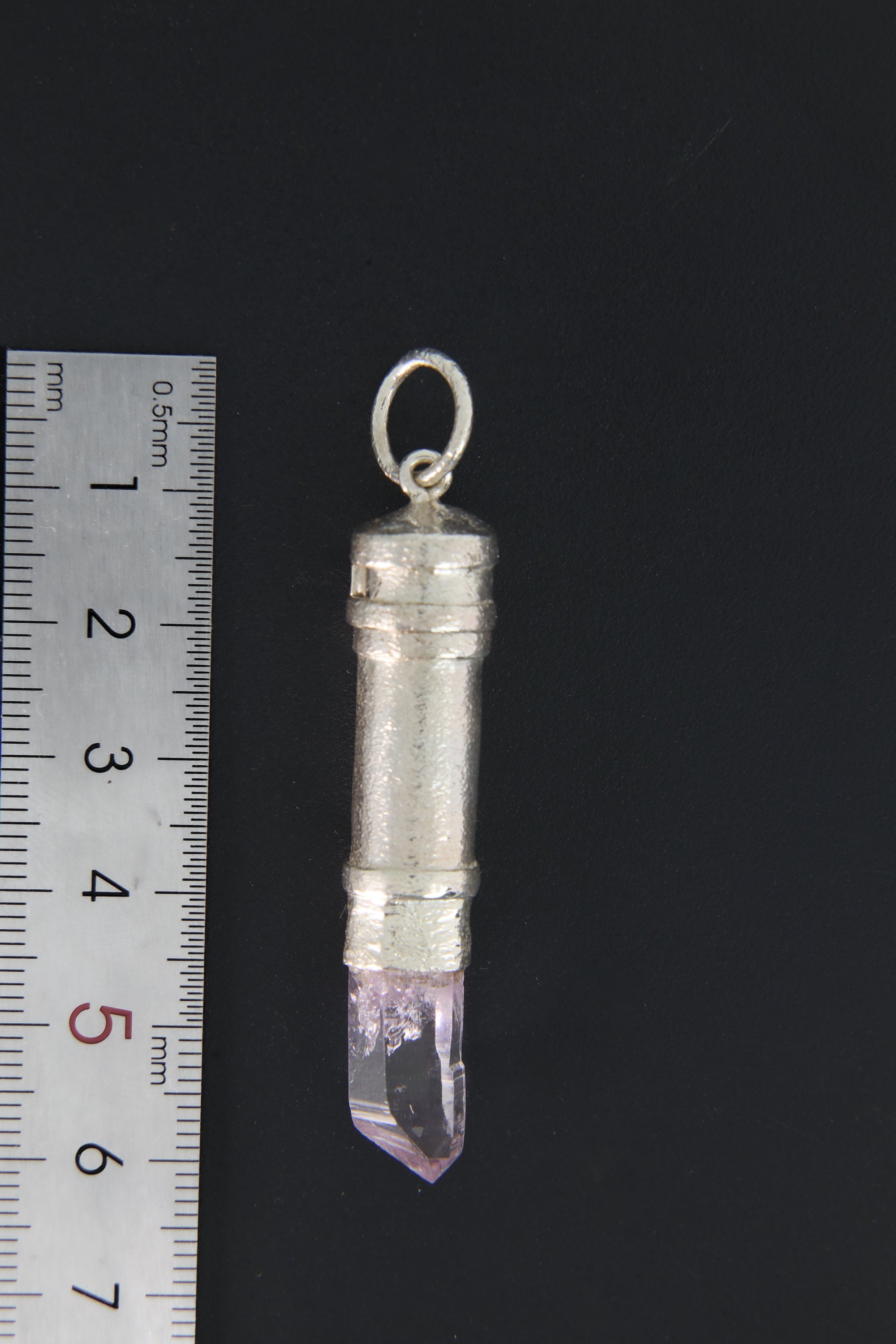 Vera Cruz Amethyst sterling silver capsule pendant shown beside a ruler for scale, with raw crystal point and round bail.