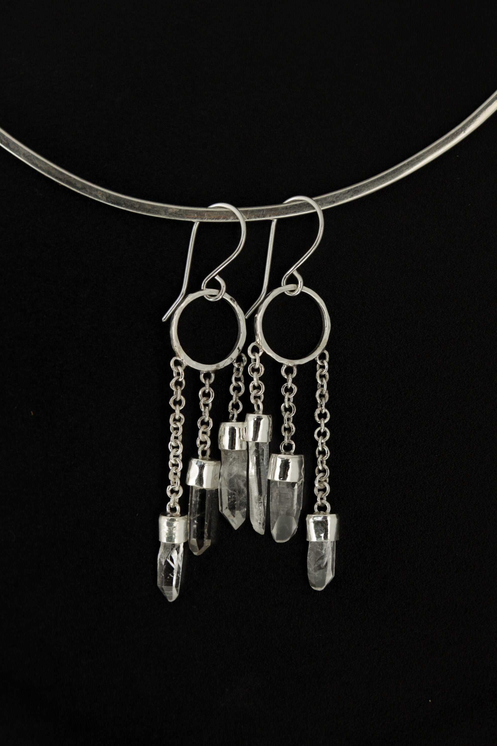 Australian Quartz Point earrings shown on dark background with hammered silver circles and three crystal chain dangles.