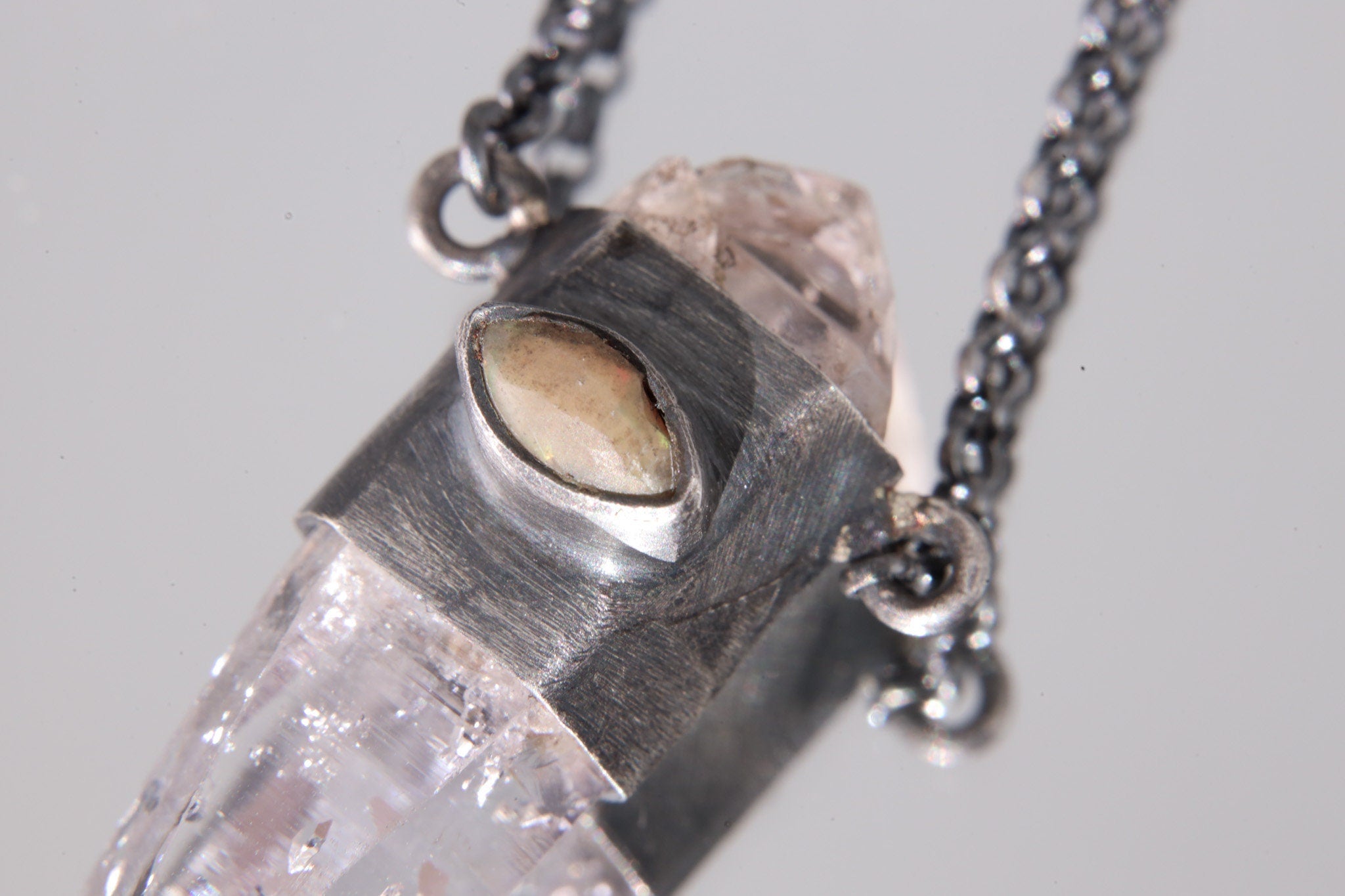 Close-up of Cat’s Eye Ethiopian Opal set into oxidized sterling silver beside Double Terminated Vera Cruz Amethyst.