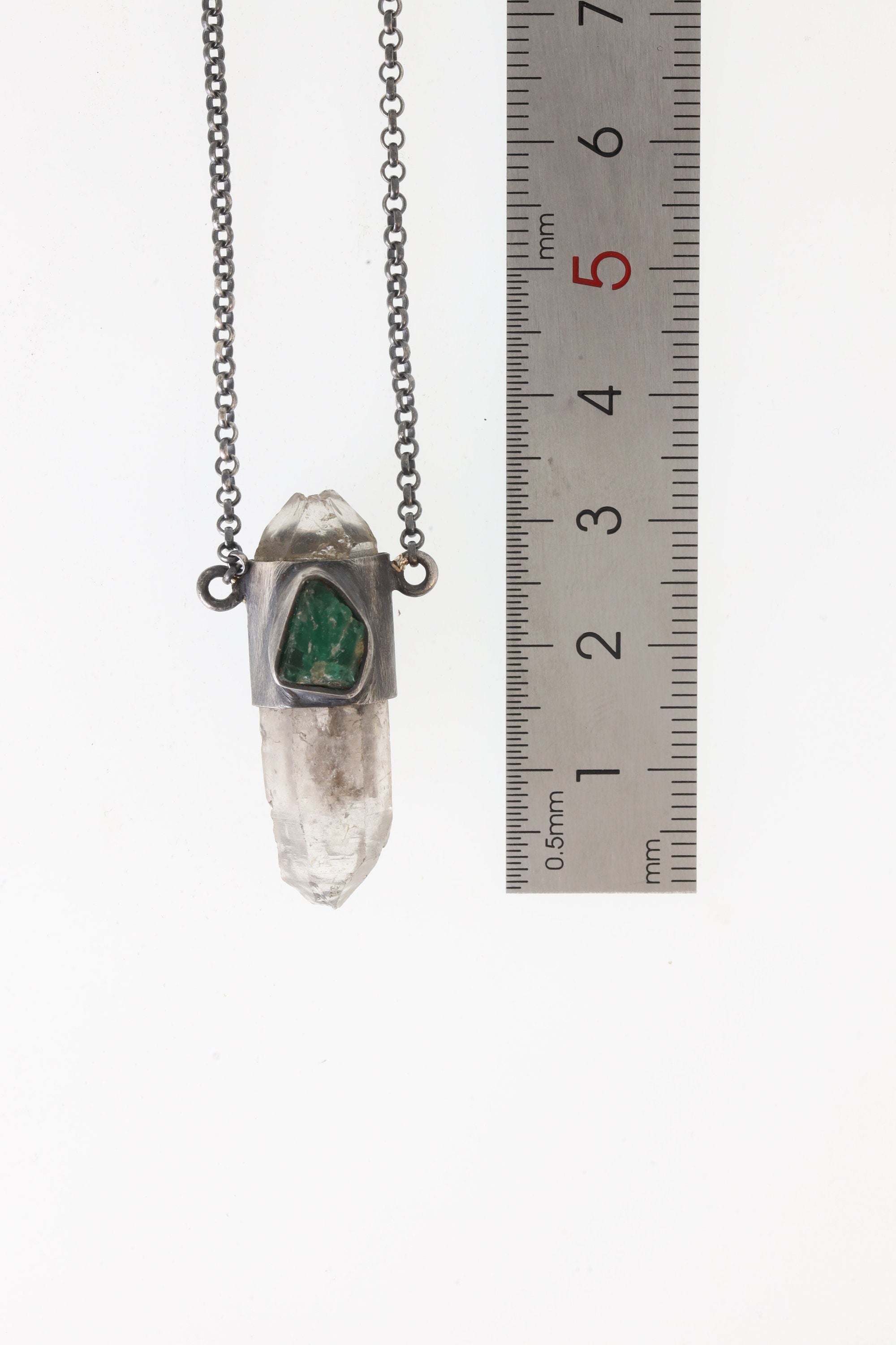 Vera Cruz Amethyst Emerald Pendant shown worn at an angle with oxidized sterling silver chain and raw green Emerald detail.