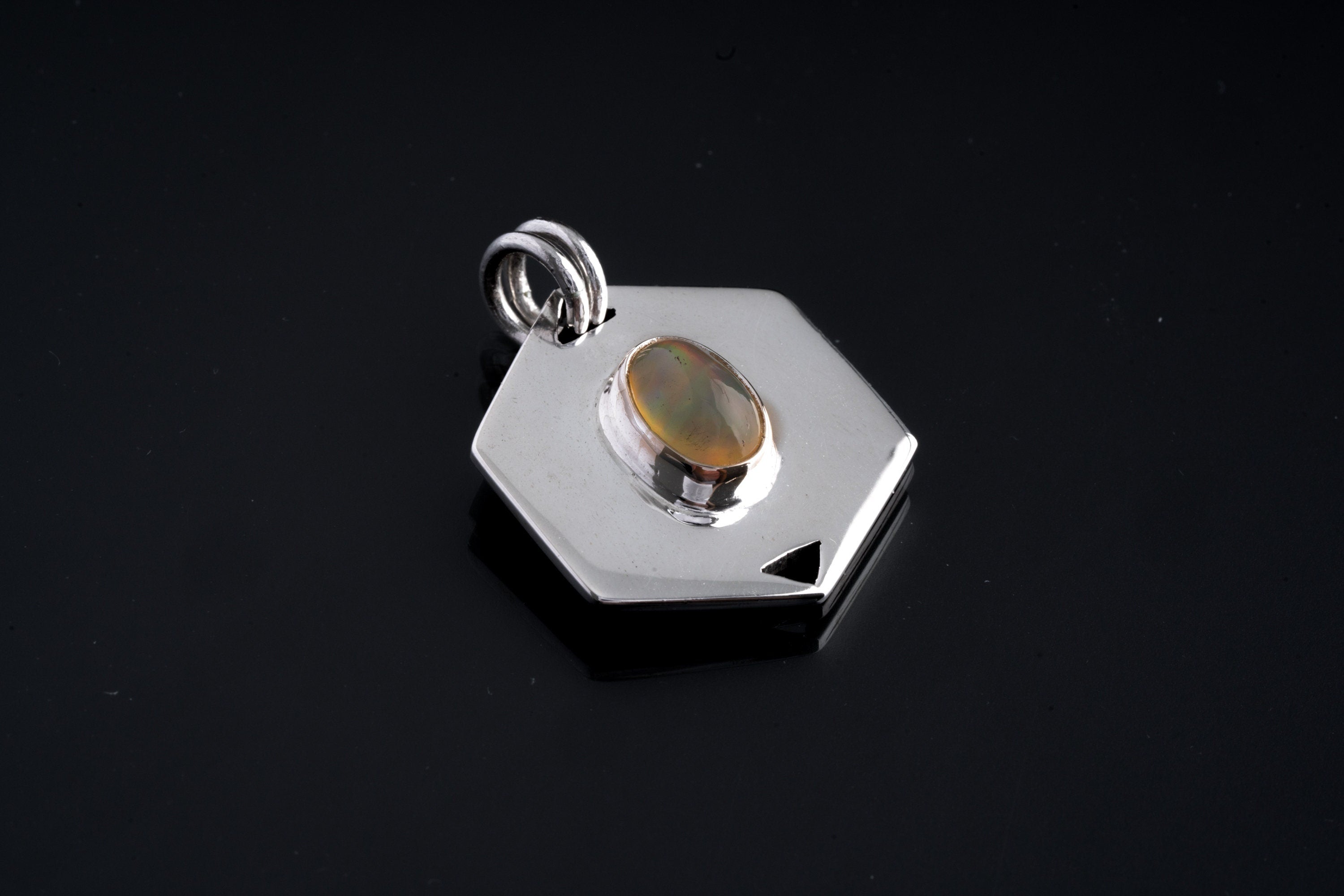 Ethiopian Opal sterling silver pendant shown close-up with fiery oval cabochon and circular dual-support bail.